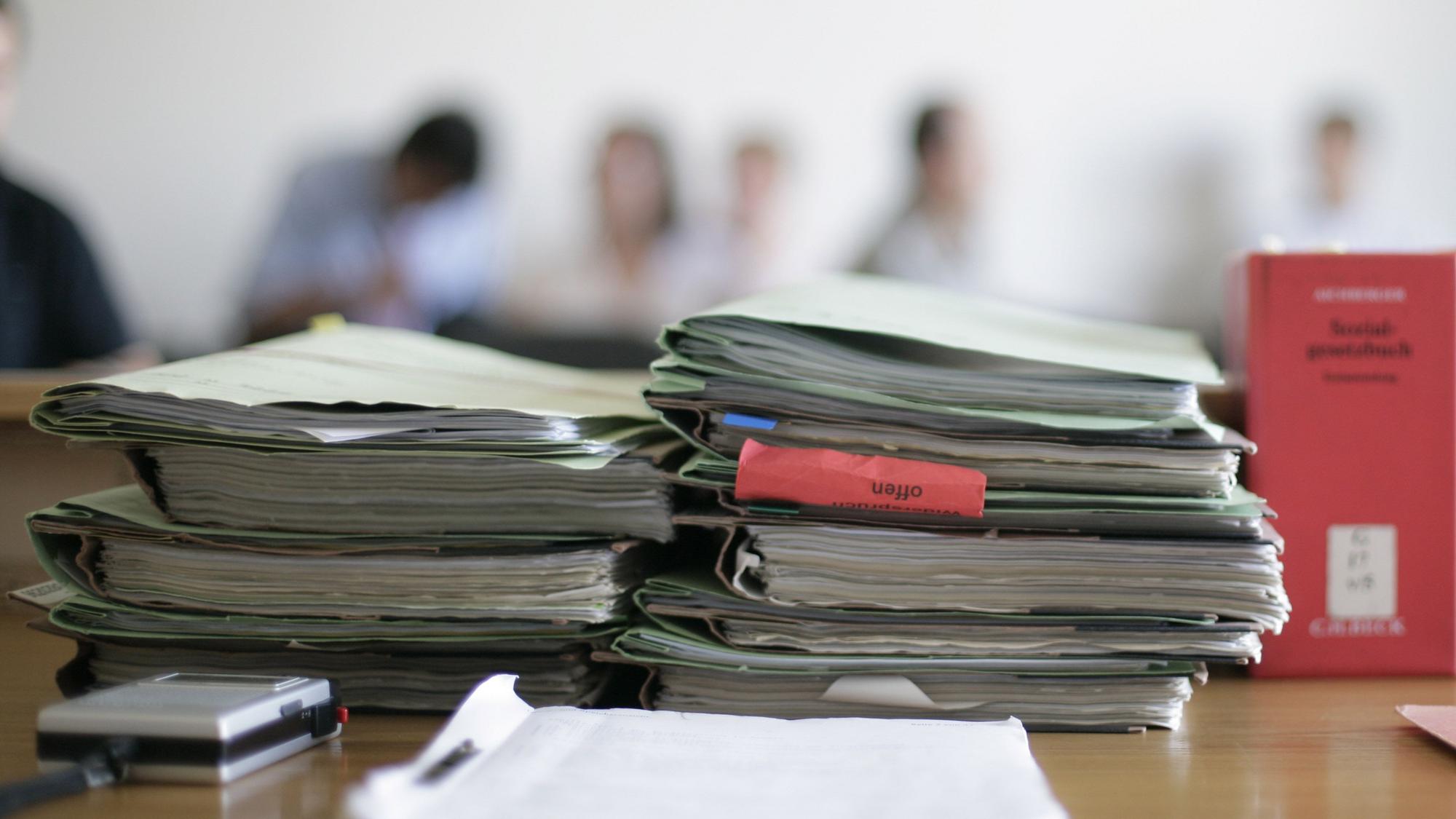 Aktenordner liegen im Sozialgericht zu Beginn einer Verhandlung auf dem Tisch.