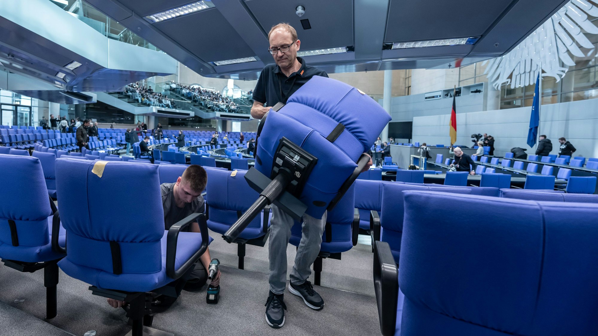 Handwerker bauen den Plenarsaal im Deutschen Bundestag für die konstituierende Sitzung des 21. Deutschen Bundestag und die neue Legislaturperiode um.