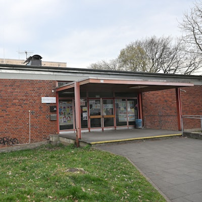 Man sieht den Eingang des einstöckigen Schulgebäudes.