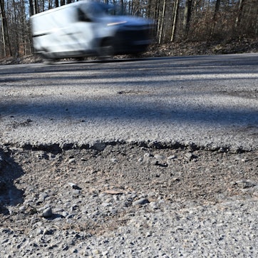 Schäden auf einem Weg an einer Landstraße.