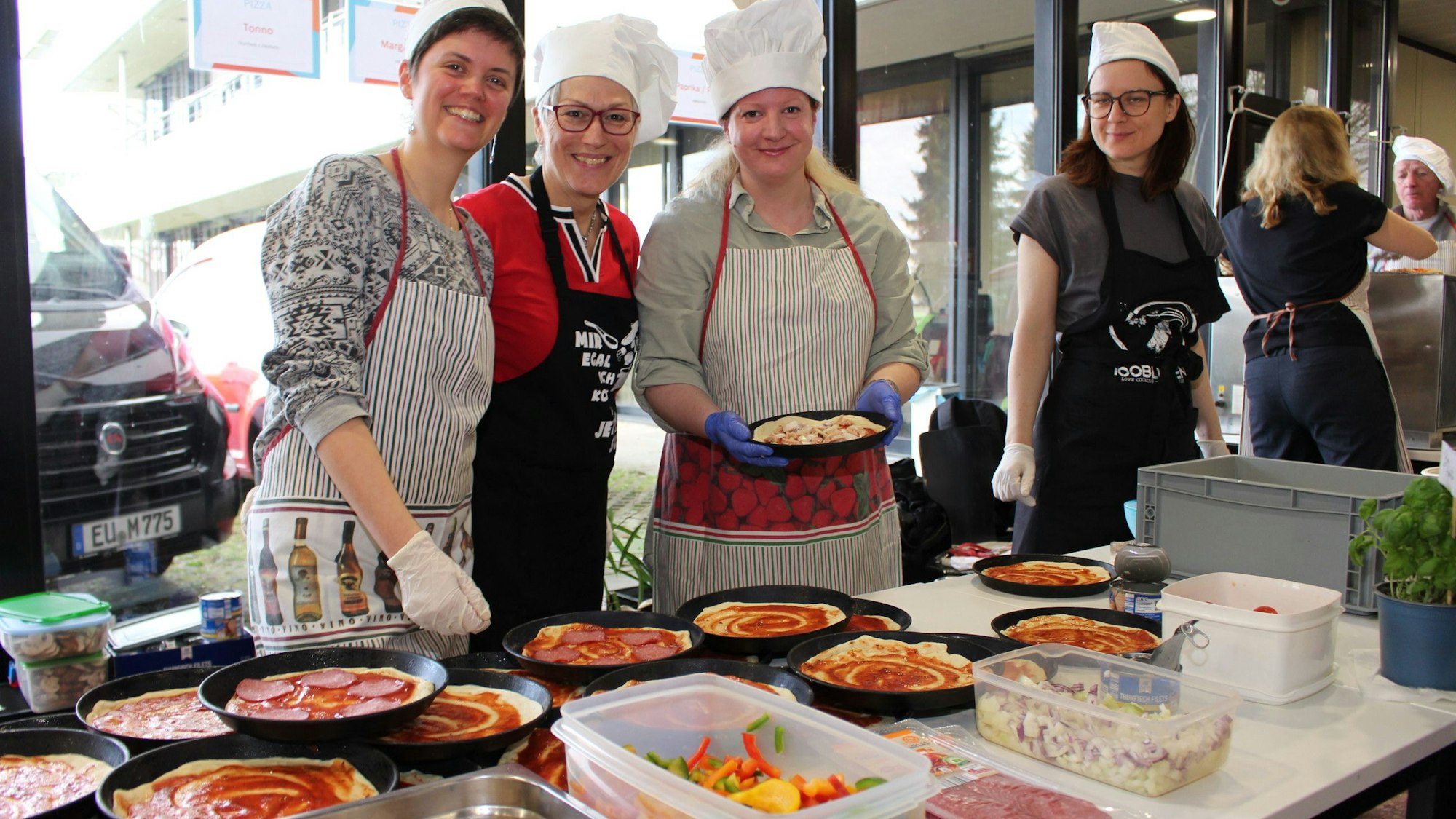 Mitarbeiterinnen der Kreisverwaltung belegen Pizzen.