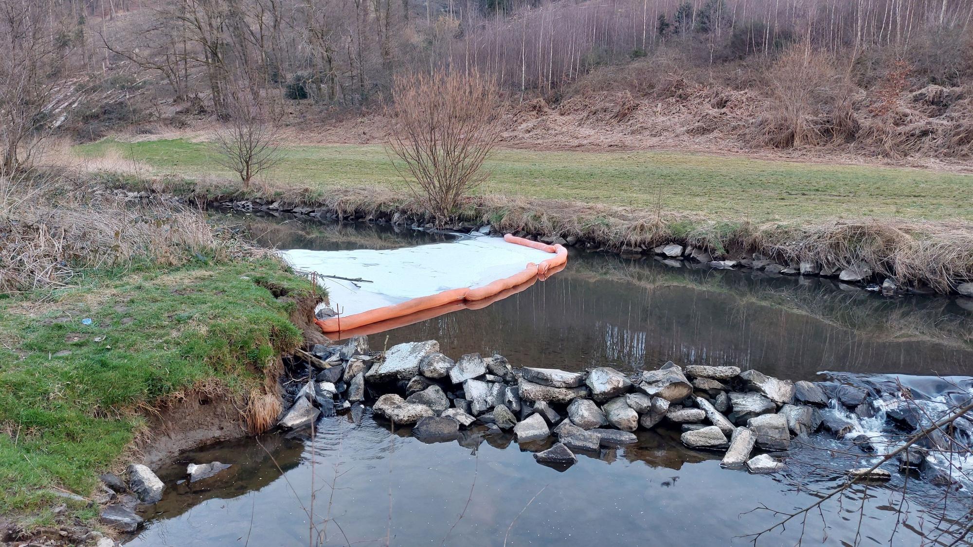 Ein weißer Teppich mit orangefarbenem Rand liegt auf dem Fluss.