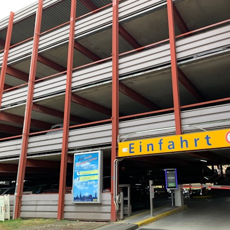 Das Foto zeigt die Einfahrt des Parkhauses mit Schranke und Monitor.