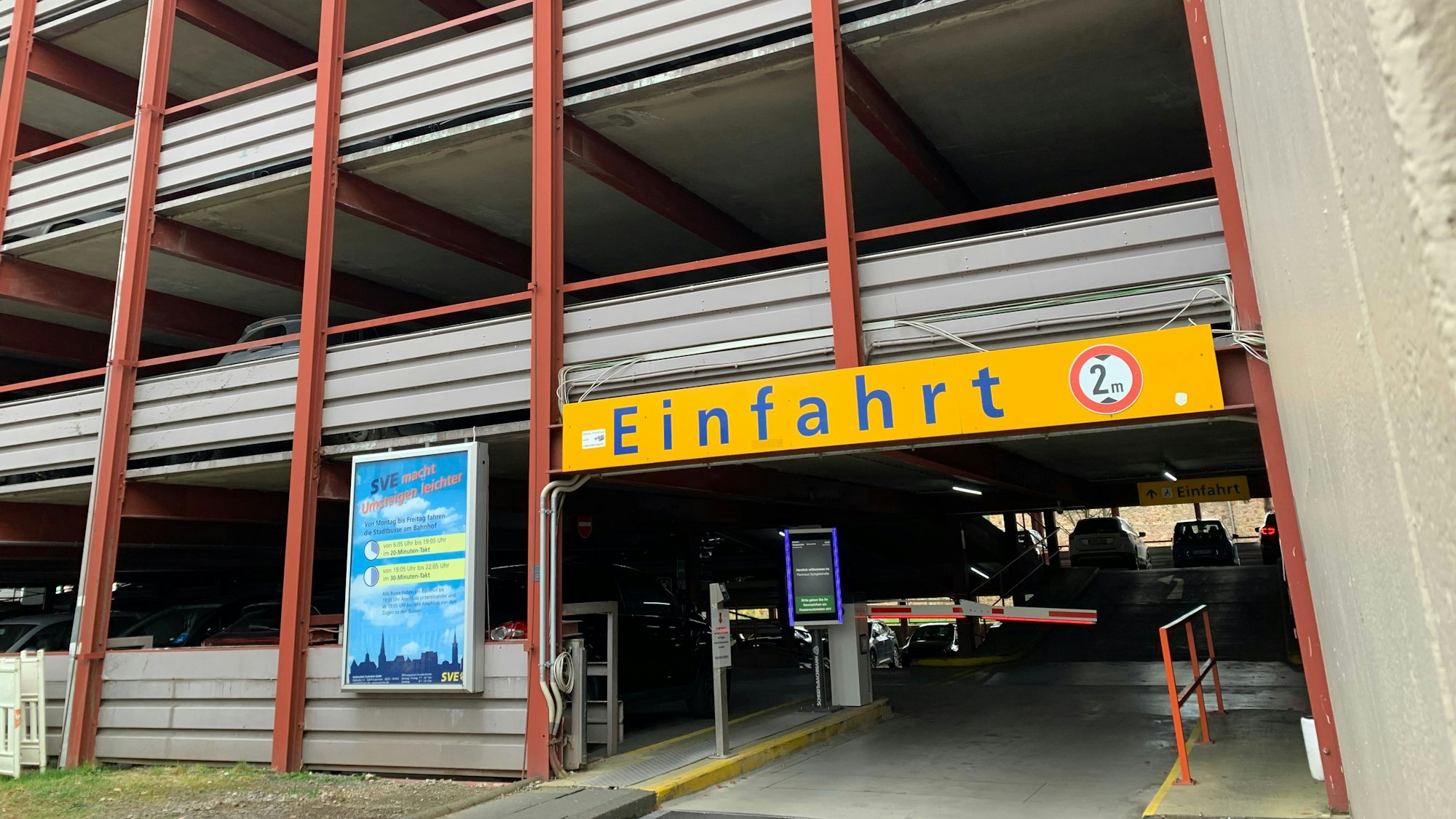 Das Foto zeigt die Einfahrt des Parkhauses mit Schranke und Monitor.