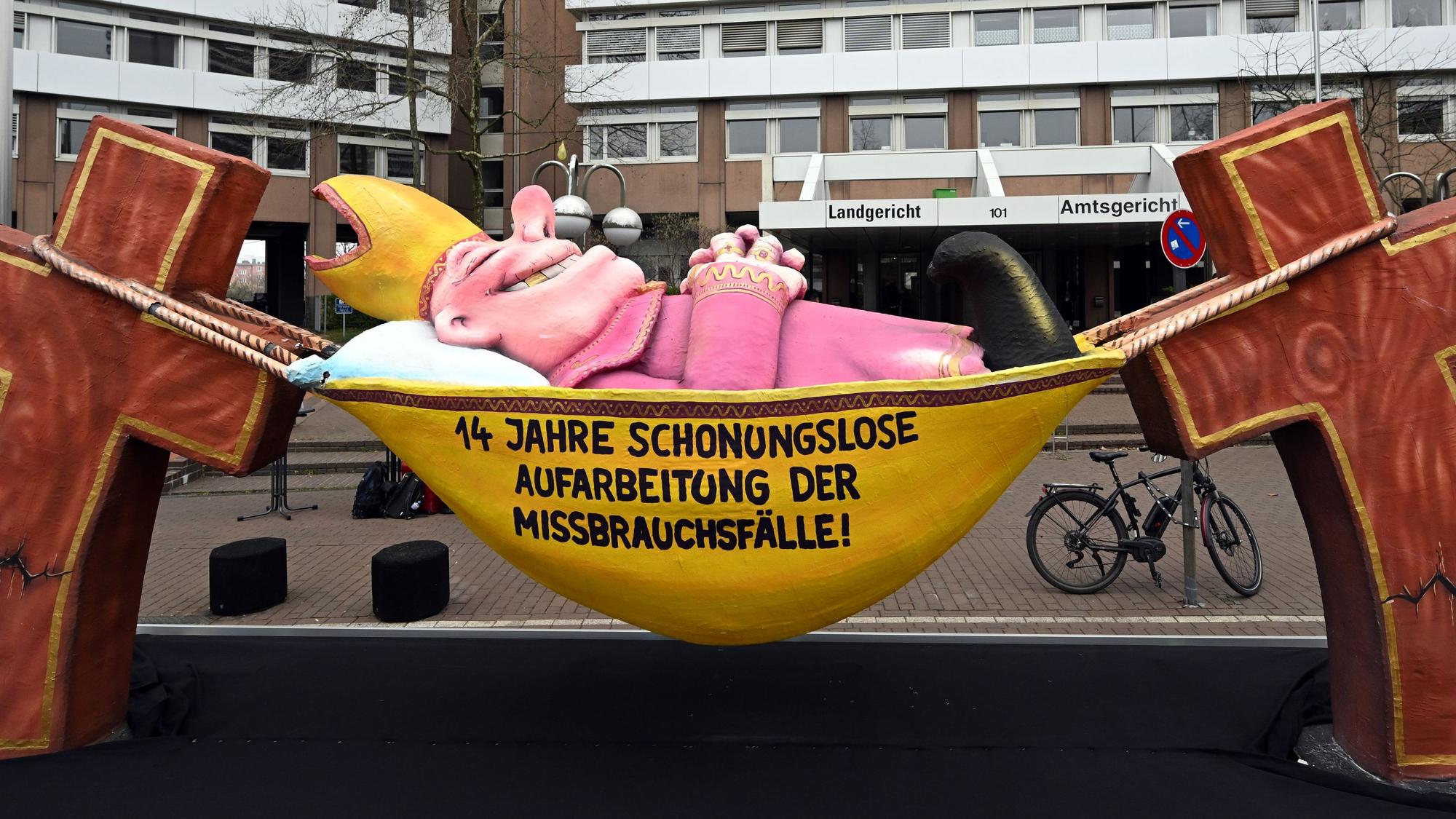 Ein Mottowagen, gebaut von Jacques Tilly und aufgestellt von der Giordano Bruno Stiftung für das bundesweite Aktionsbündnis der Betroffeneninitiativen, steht vor dem Landgericht in Köln.