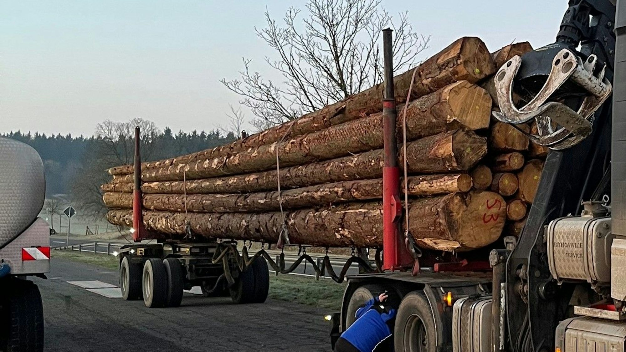 Ein Langholztransporter steht auf einem Parkplatz.