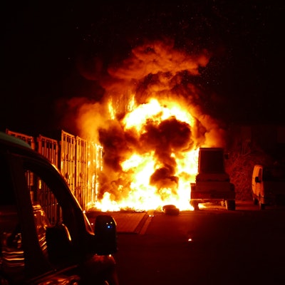 Ein brennender Reifenstapel neben einem Radlader.