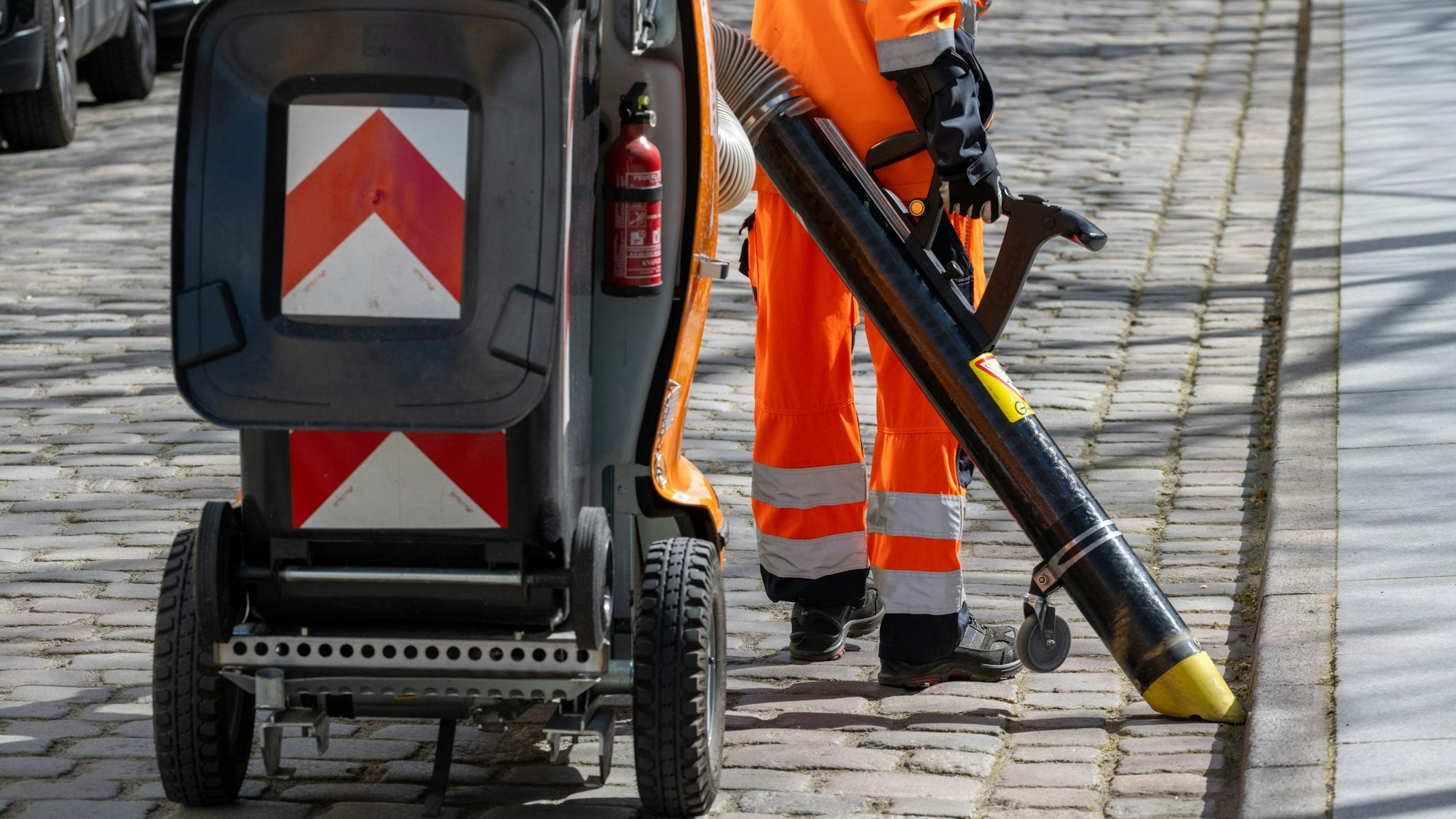 Ein Mitarbeiter putzt eine Straße mit einem Elektro-Stadtsauger.
