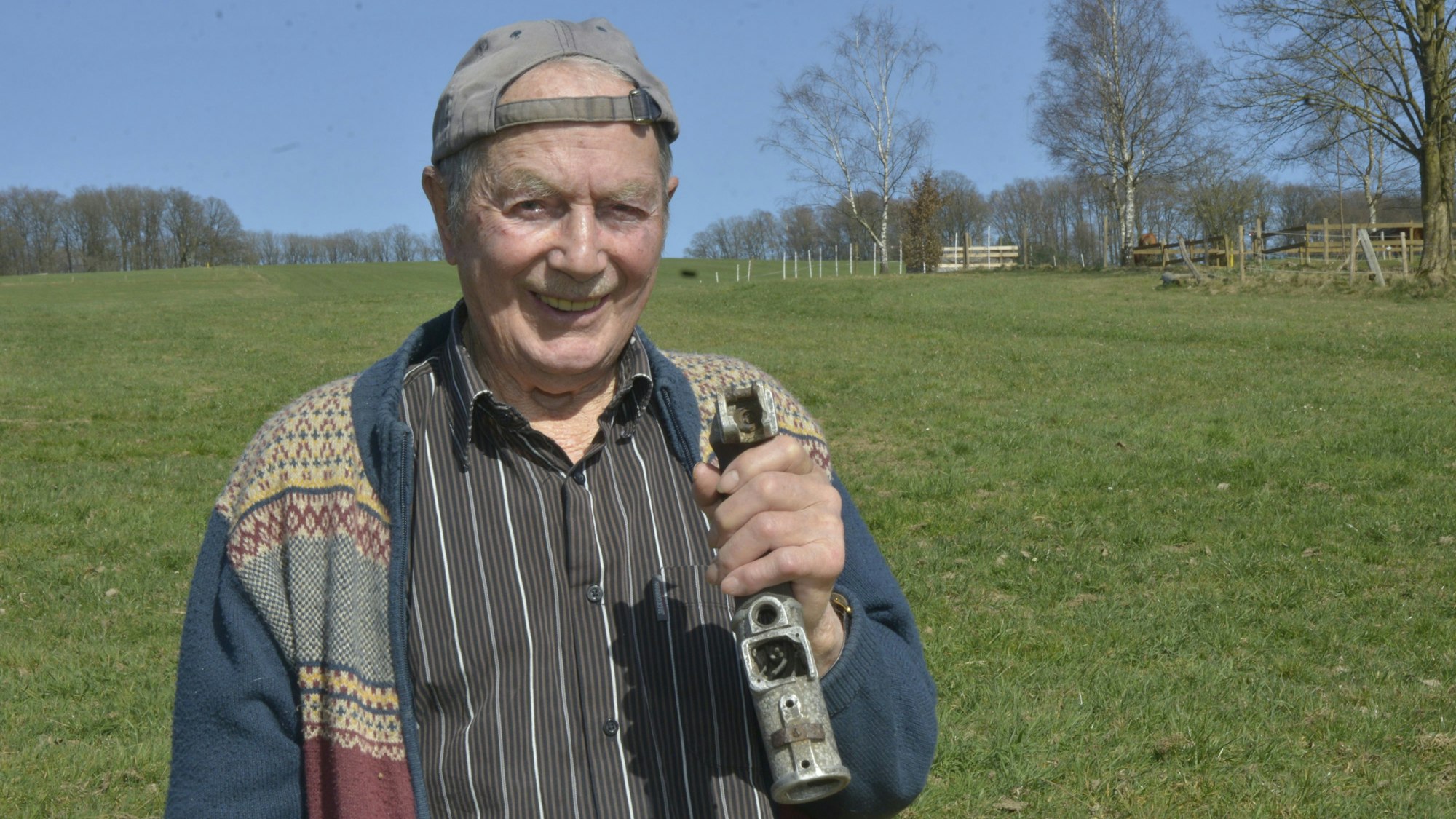 Vor der Wiese, auf der das Flugzeug notlandete, zeigt Hans Förster den Steuerknüppel, den er vor 80 Jahren aus der Maschine ausgebaut hat.