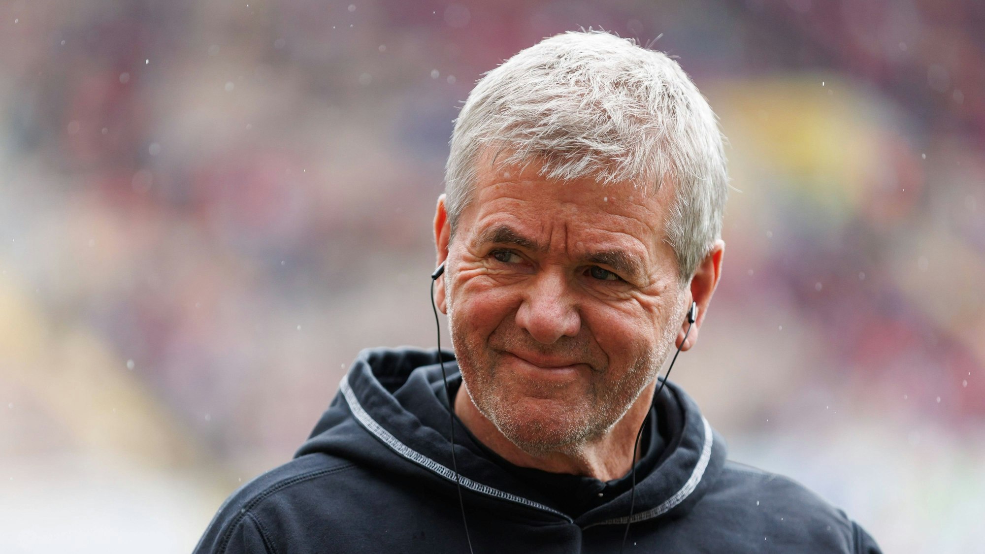 Friedhelm Funkel mit Kopfhörern.