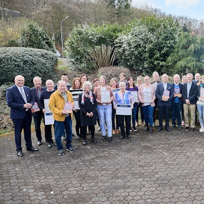 Die Träger des Heimatpreises 2025 der Stadt Heimbach stehen in einem Halbkreis auf einem Hof.