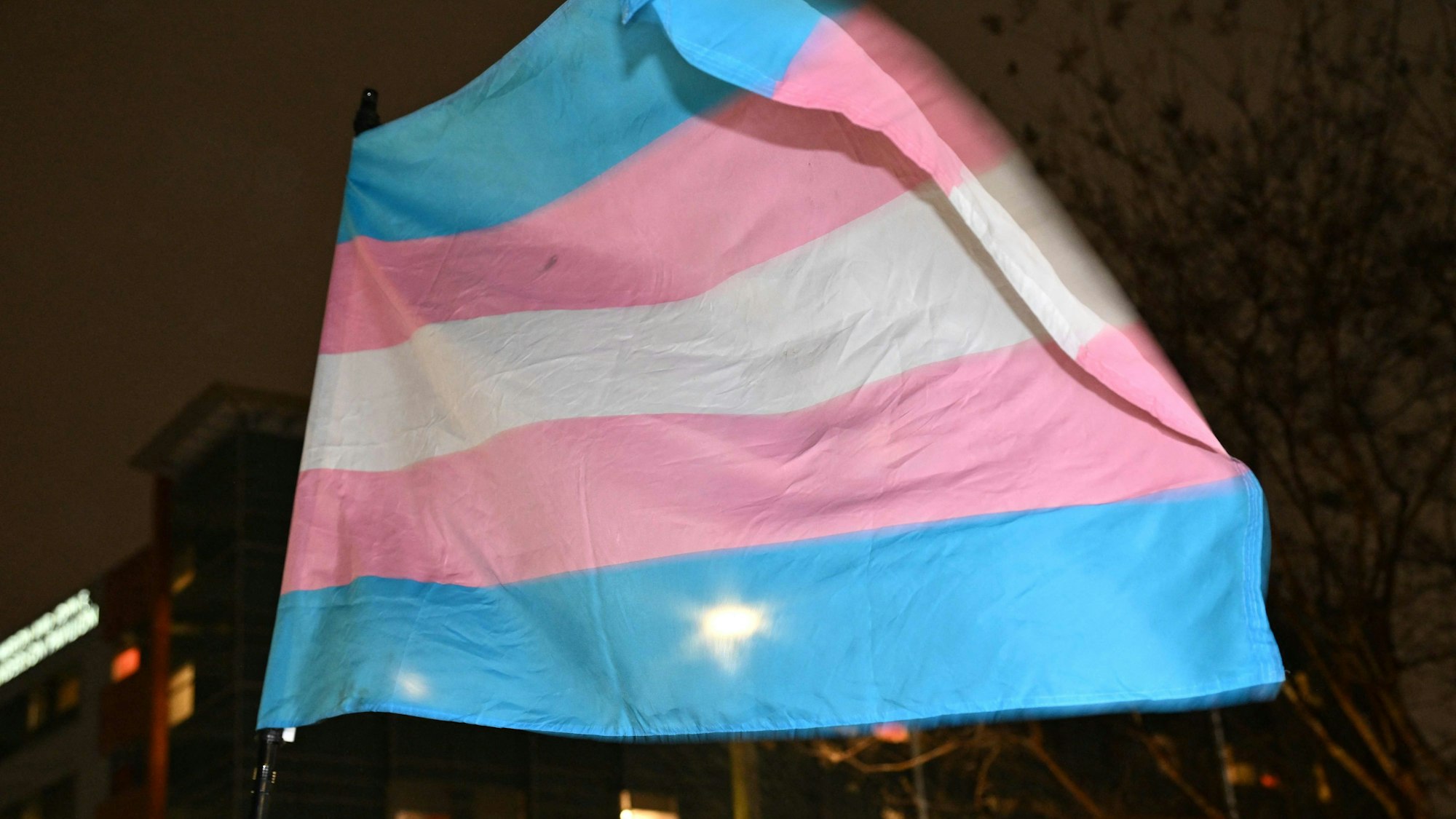 Supporters of transgender youth hold a Transgender Pride flag as they demonstrate outside Children's Hospital Los Angeles (CHLA) on February 6, 2025 in the wake of US President Donald Trump's executive order threatening to pull federal funding from healthcare providers who offer gender-affirming care to children. The hospital announced on February 4 it was pausing the initiation of hormonal therapy for gender affirming care patients under the age of 19 as they evaluate the Executive Order "to fully understand its implications." The announcement came after US President Donald Trump signed an executive order on January 28 to restrict gender transition procedures for minors. (Photo by Robyn Beck / AFP)