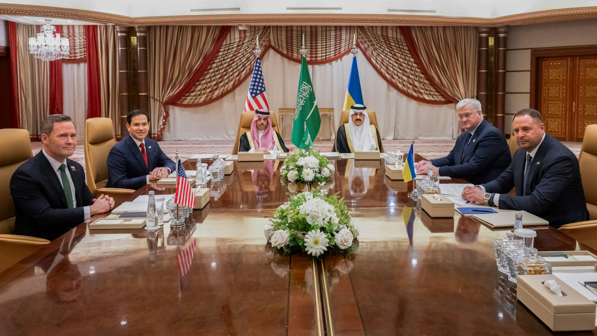 Mike Waltz (l-r), nationaler Sicherheitsberater der USA, Marco Rubio, US-Außenminister, der saudi-arabische Außenminister Prinz Faisal bin Farhan, der saudi-arabische nationale Sicherheitsberater Mosaad bin Mohammad al-Aiban, der ukrainische Außenminister Andrii Sybiha und der ukrainische Leiter des Präsidialamtes, Andriy Yermak, sitzen bei einem Treffen an einem Tisch.