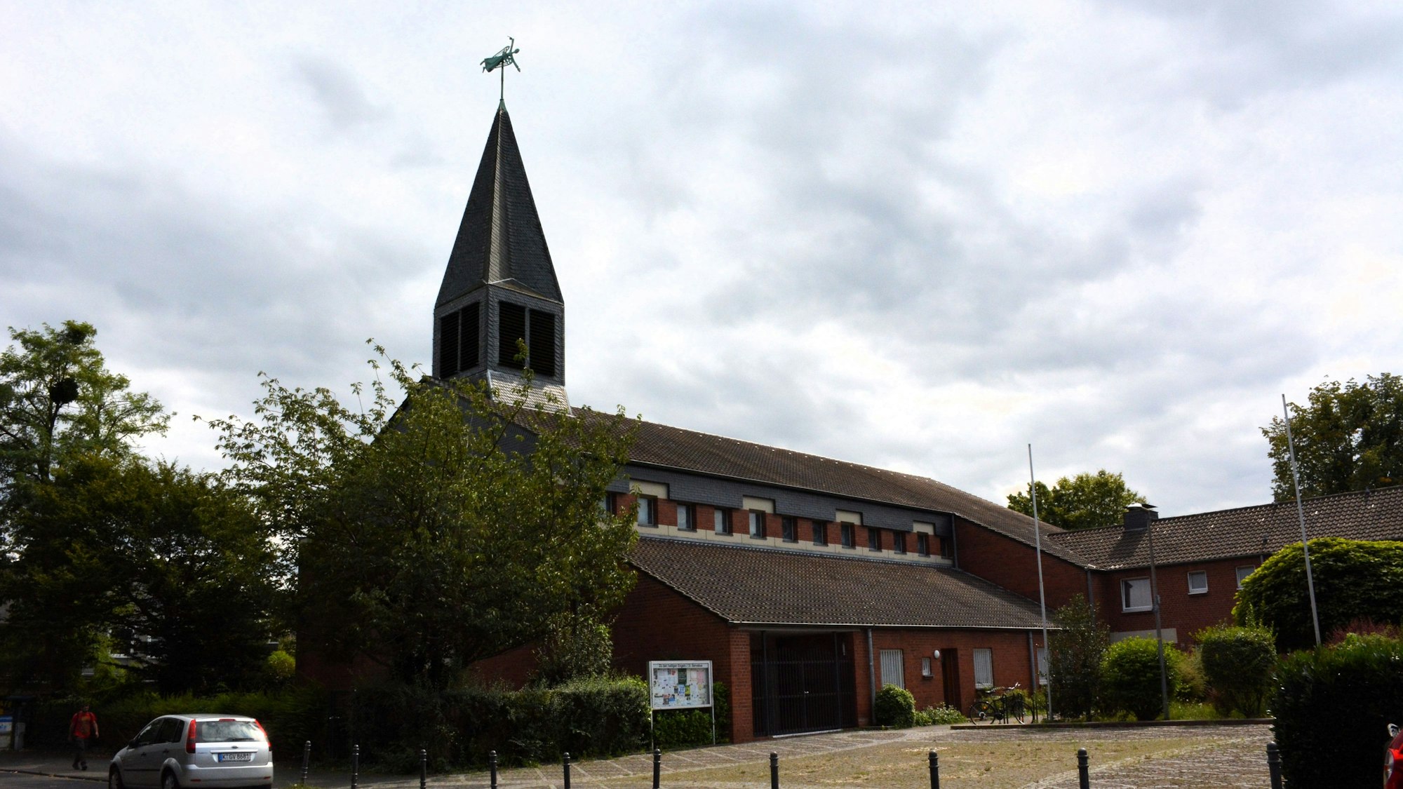 Eine katholische Kirche mit einem waagerecht aufgehängten Engel auf dem Turm