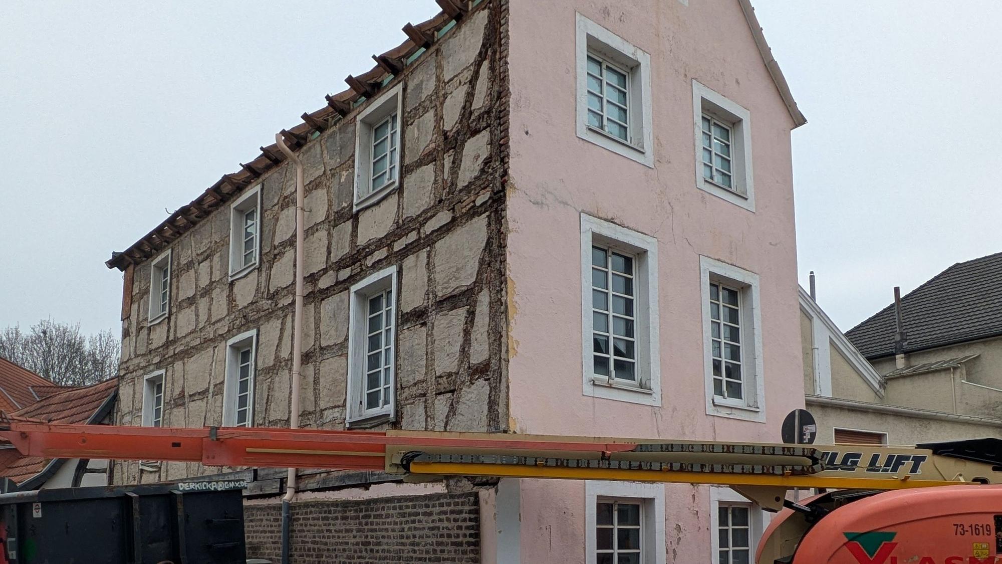 Vor dem Haus steht ein Kran, die Baustelle ist abgezäunt.