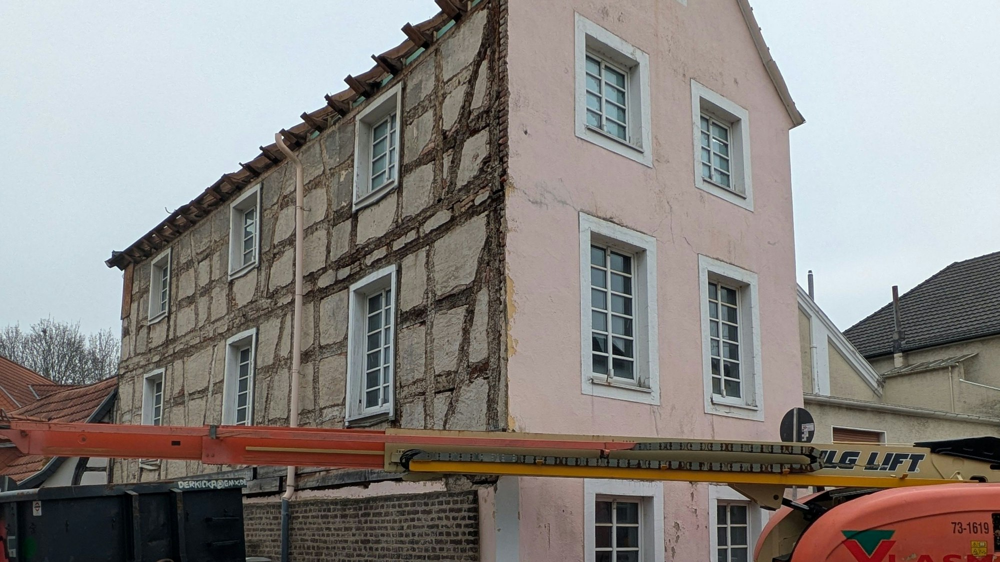 Vor dem Haus steht ein Kran, die Baustelle ist abgezäunt.