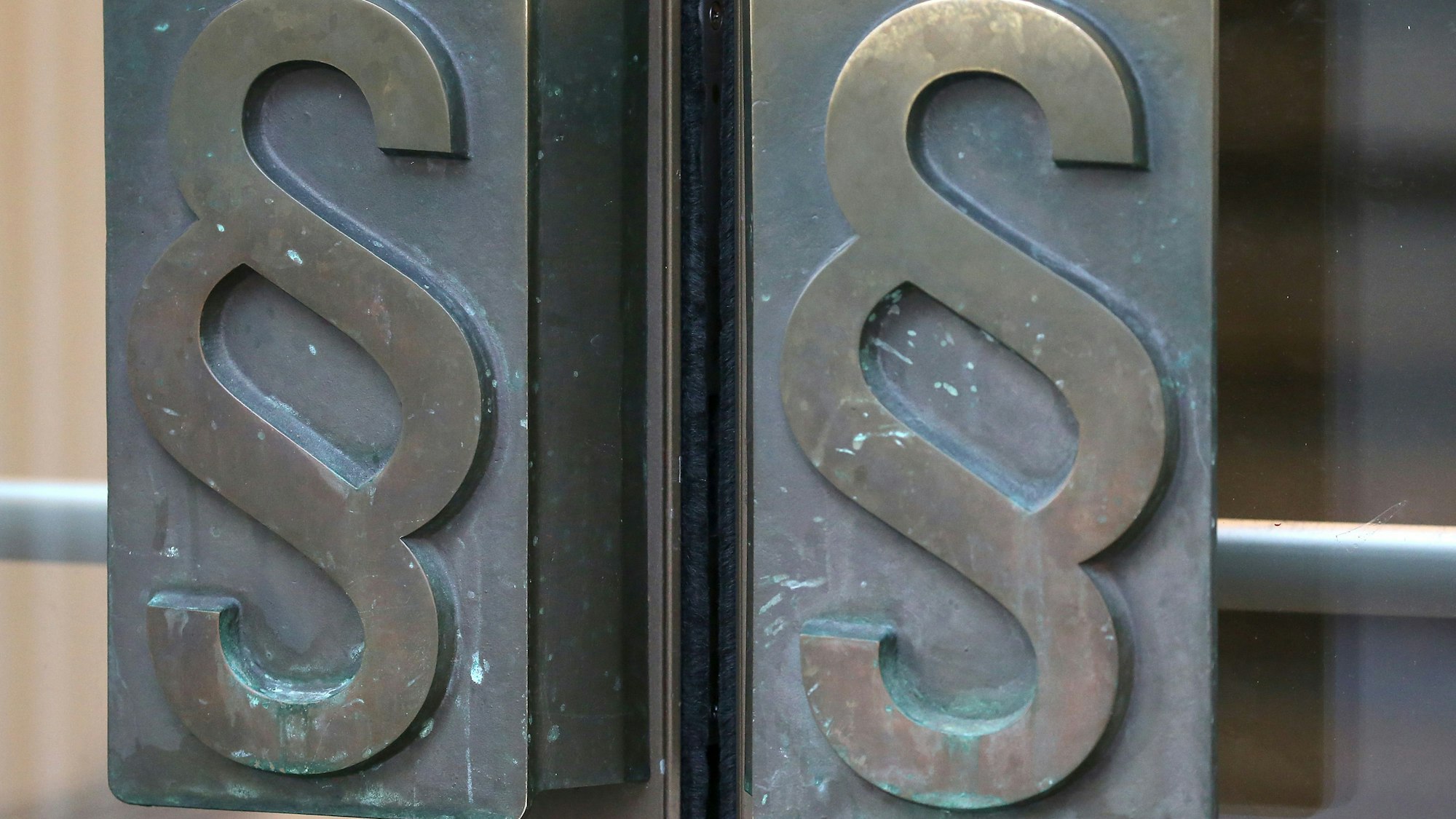 Griffe einer Tür mit Paragrafen-Symbolen.