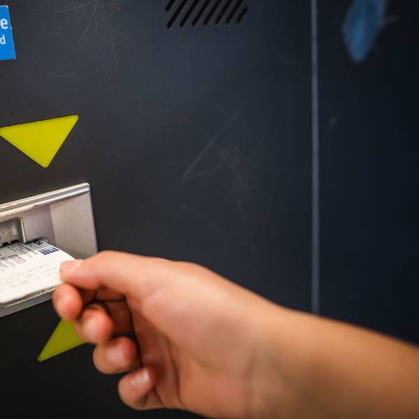 Eine Frau führt in einem Parkhaus in Stuttgart einen Parkschein in einen Automaten ein.