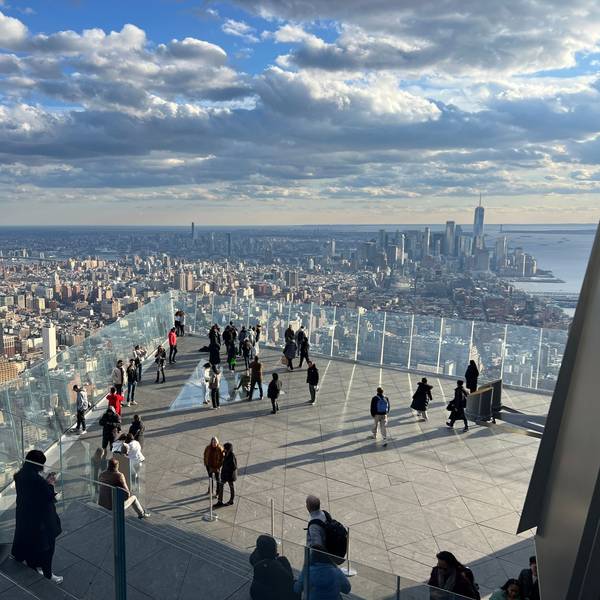 Menschen auf einer Aussichtsplattform, im Hintergrund Wolkenkratzer von Manhattan.