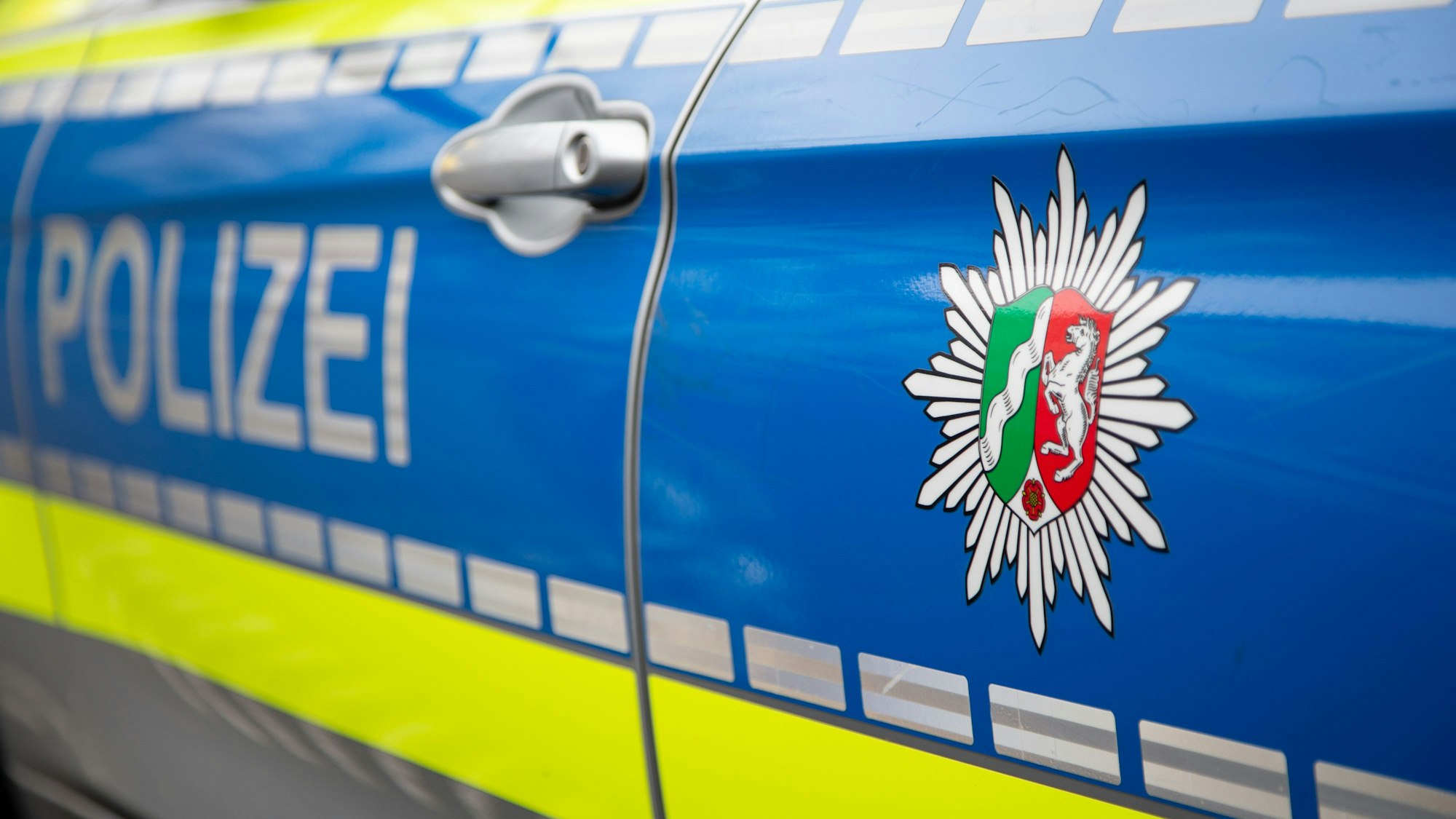 Blick auf ein Emblem der Polizei in NRW an einem Polizeiauto.