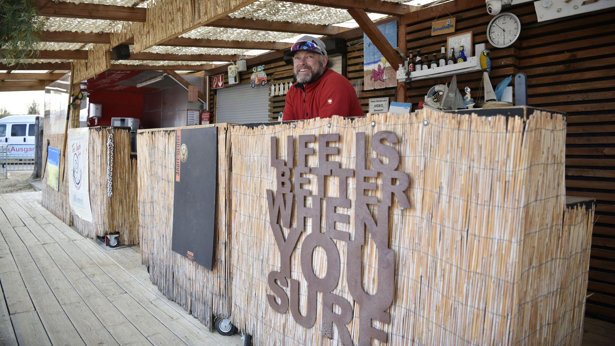 Tim Endlein steht hinter der Theke seiner Surf-Basis Tims Beach am Zülpicher Wassersportsee.