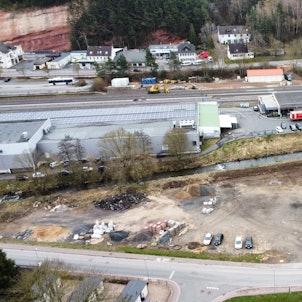 Blick auf den Platz mit Baumaterialien und dem Schwimmbad (Drohnenaufnahme).