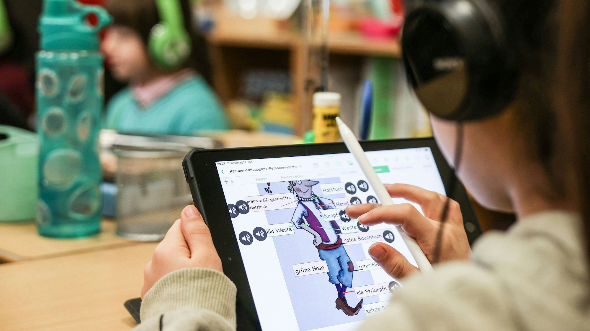 Eine Schülerin lernt in einer Klasse am iPad.