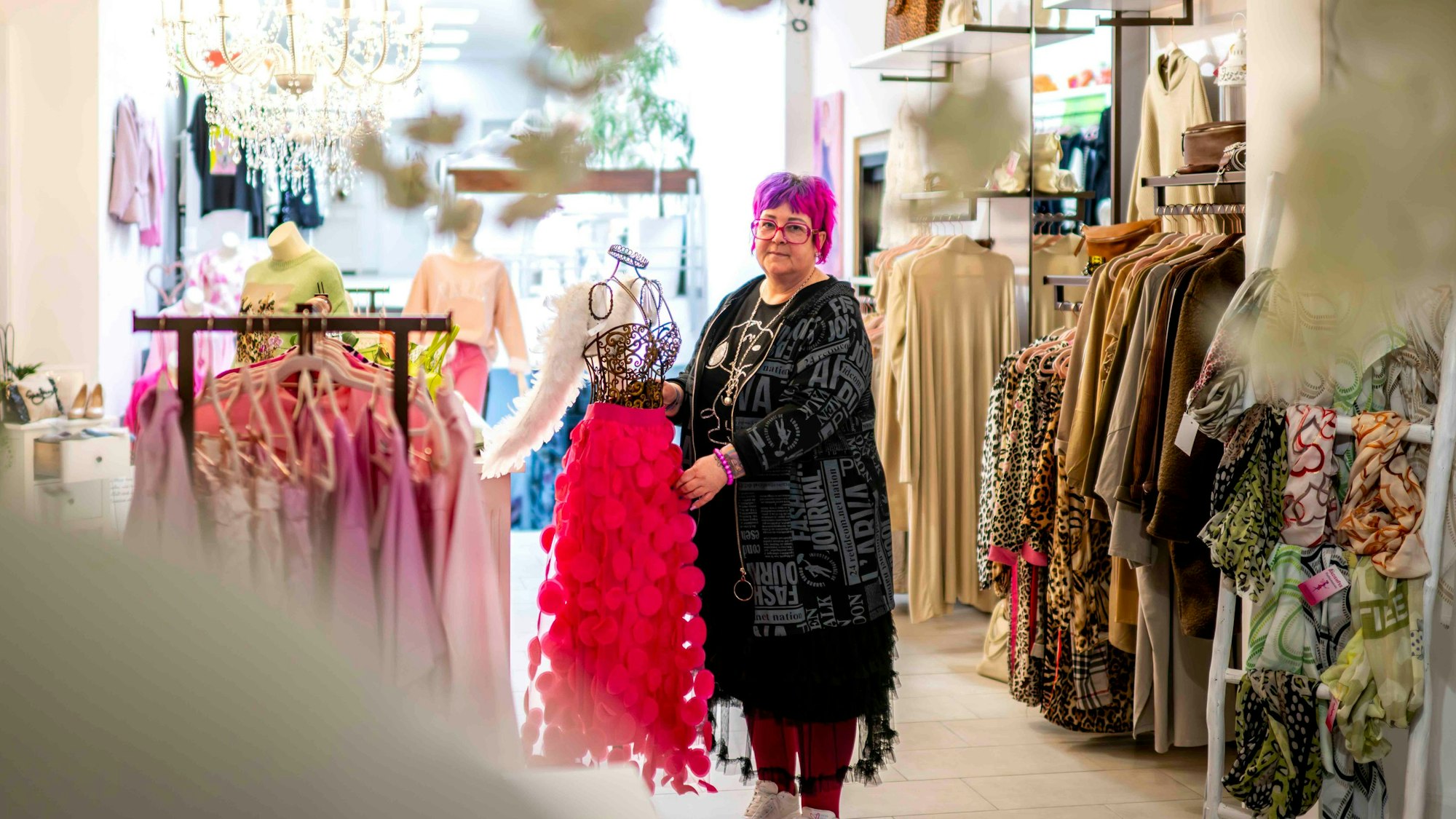 Edith Nandzig, eine der beiden Besitzerinnen, drapiert in dem Modegeschäft einen pinkfarbenen Rock auf eine Drahtpuppe.