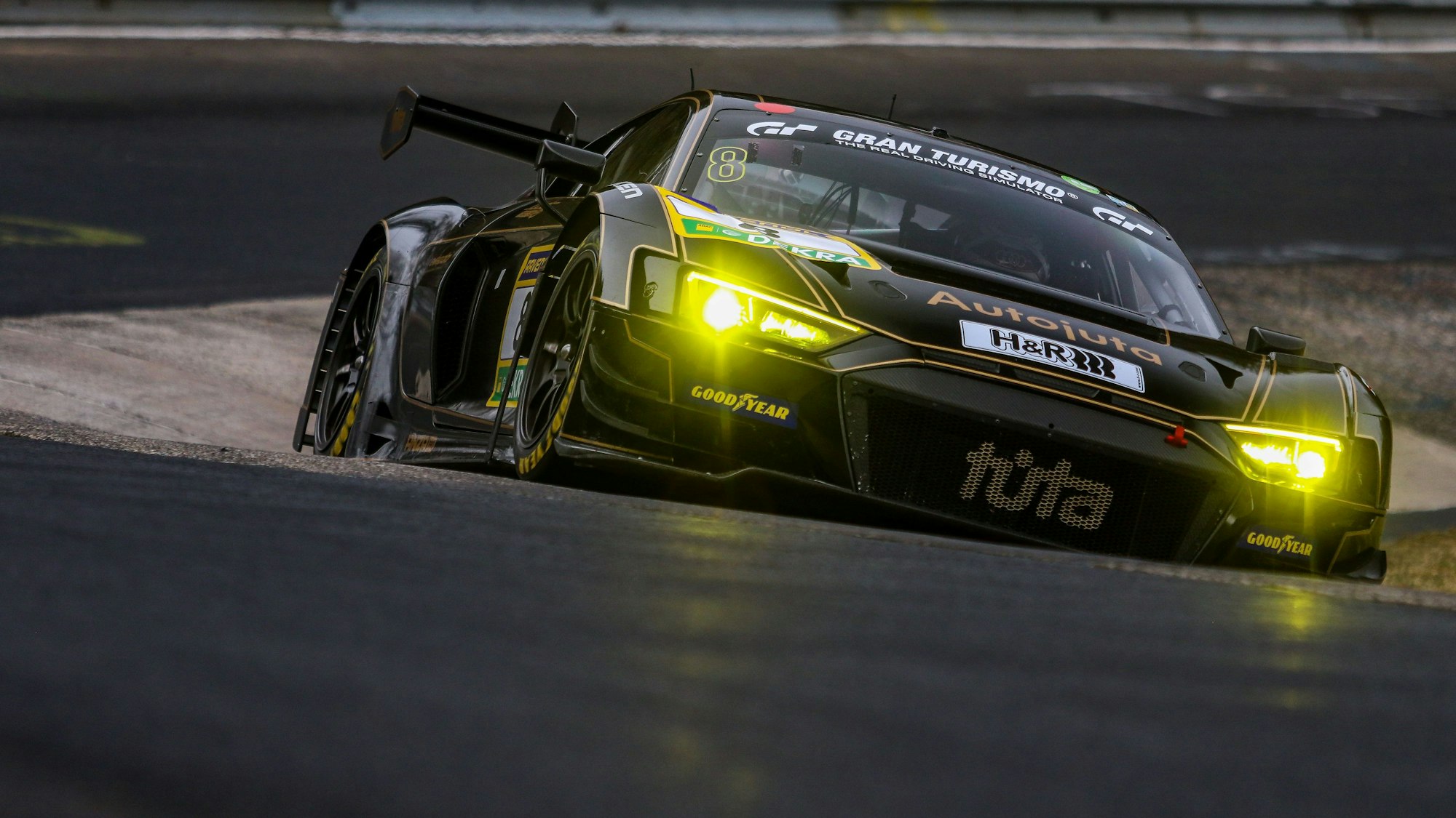 Der Audi von Frank Stippler fährt durch eine Kurve. Die Frontscheinwerfer des schwarzen Gefährts leuchten gelb.