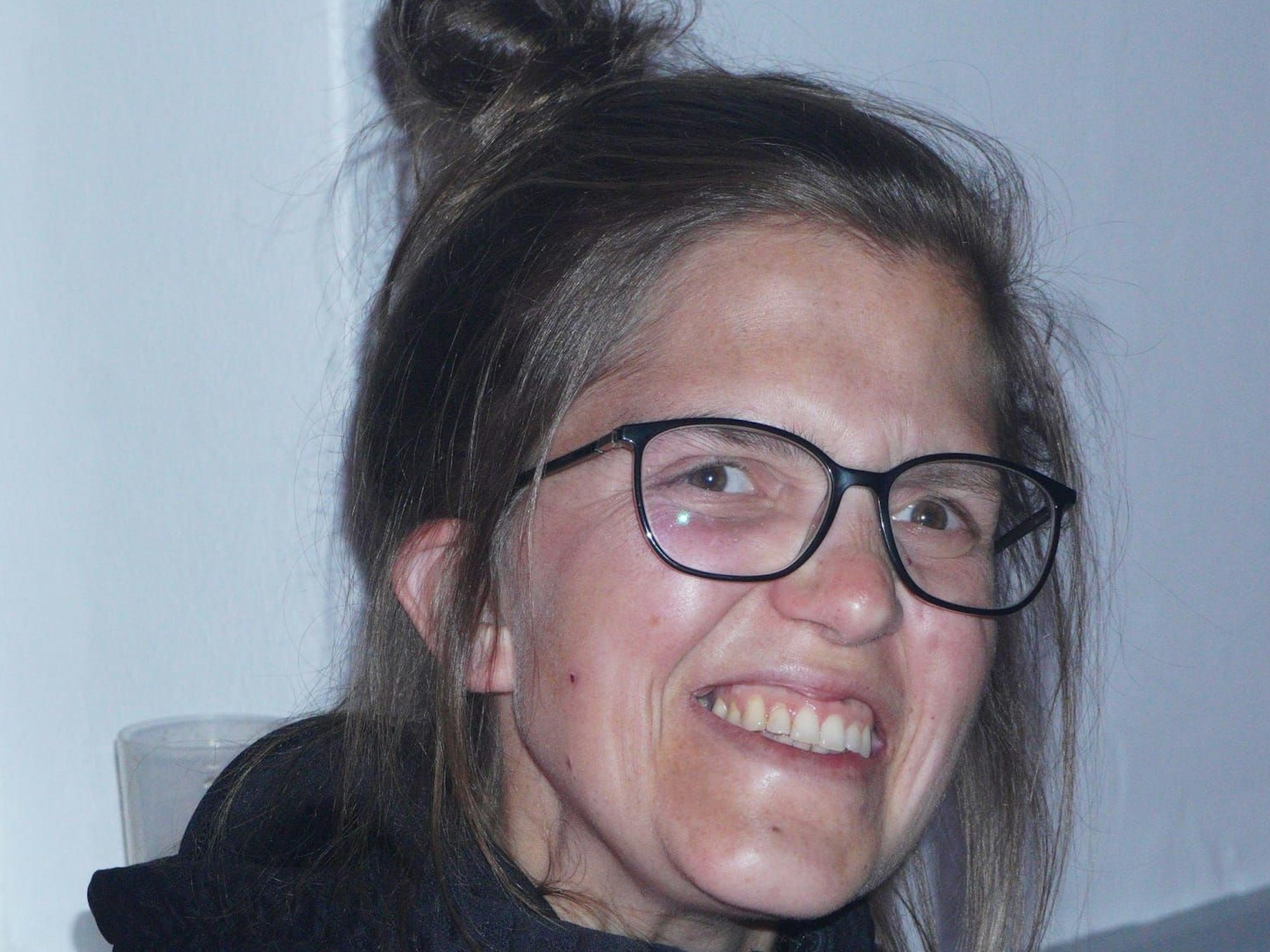 Nahaufnahme einer Frau mit Brille, die lächelt