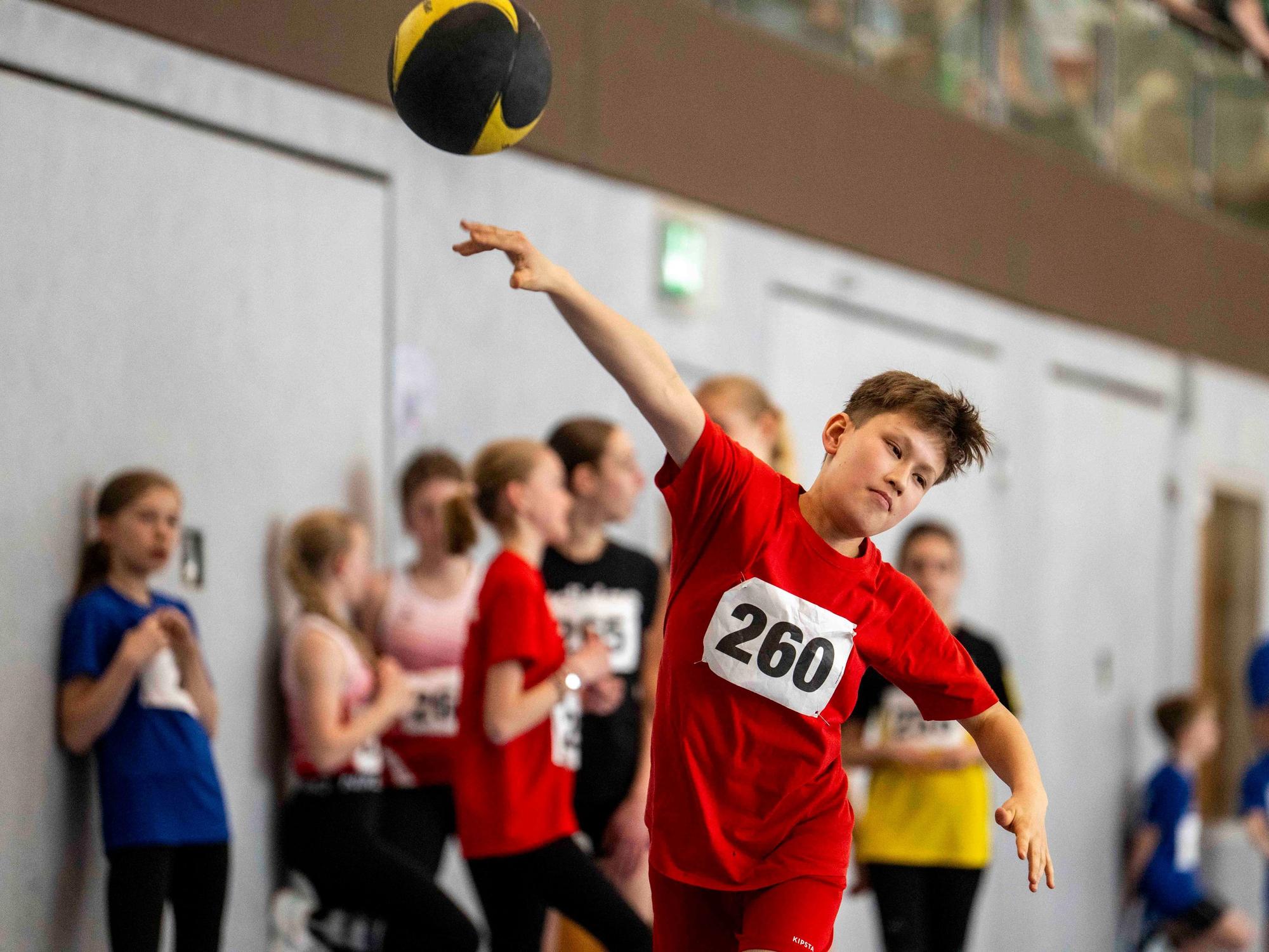 Ein junger Sportler wirft einen Medizinball.