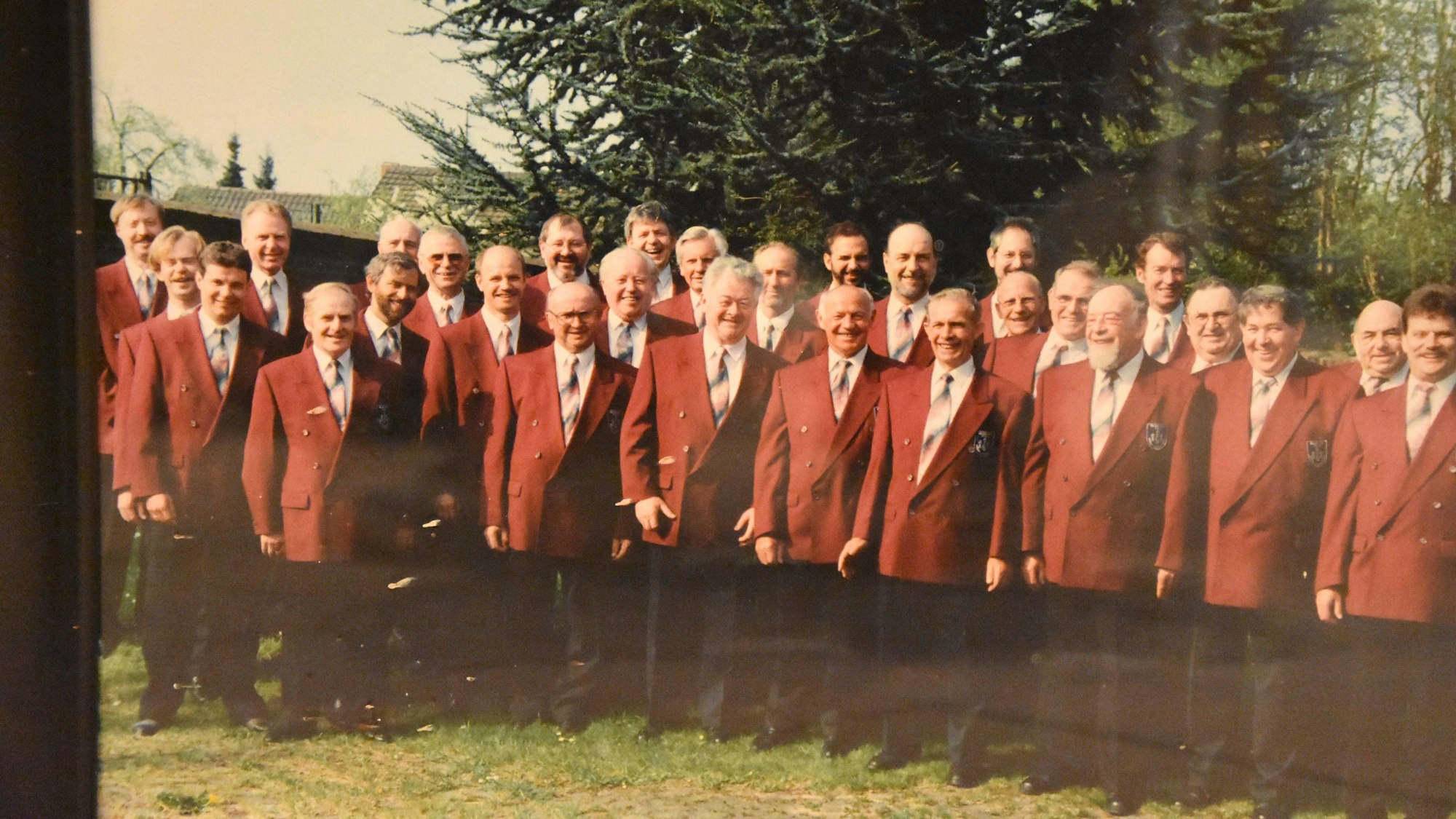 Das Foto zeigt eine Gruppe von Chorsängern in roten Jacketts.