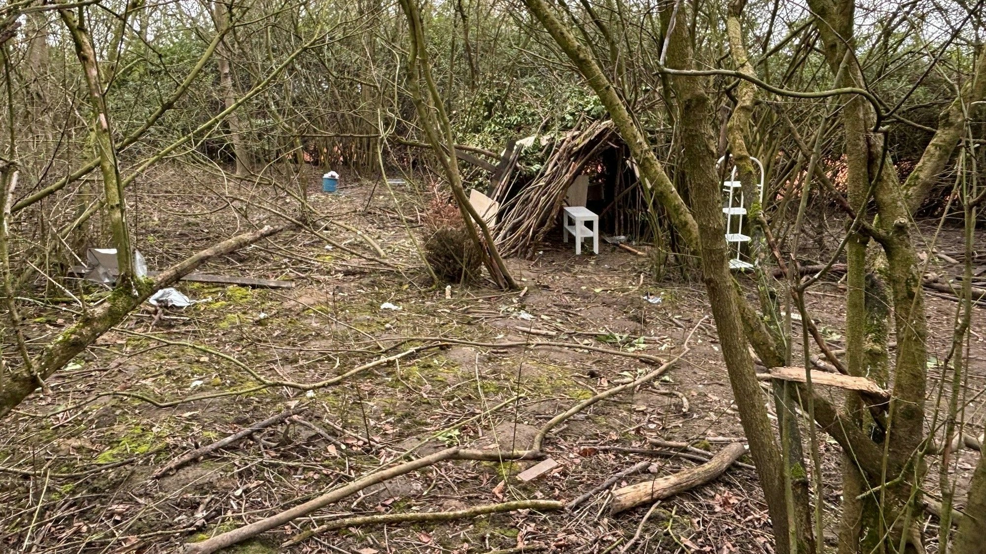Auf dem Bild ist ein Teil des Grundstücks zu sehen, auf dem ein Tipi gebaut ist und Müll herum liegt.