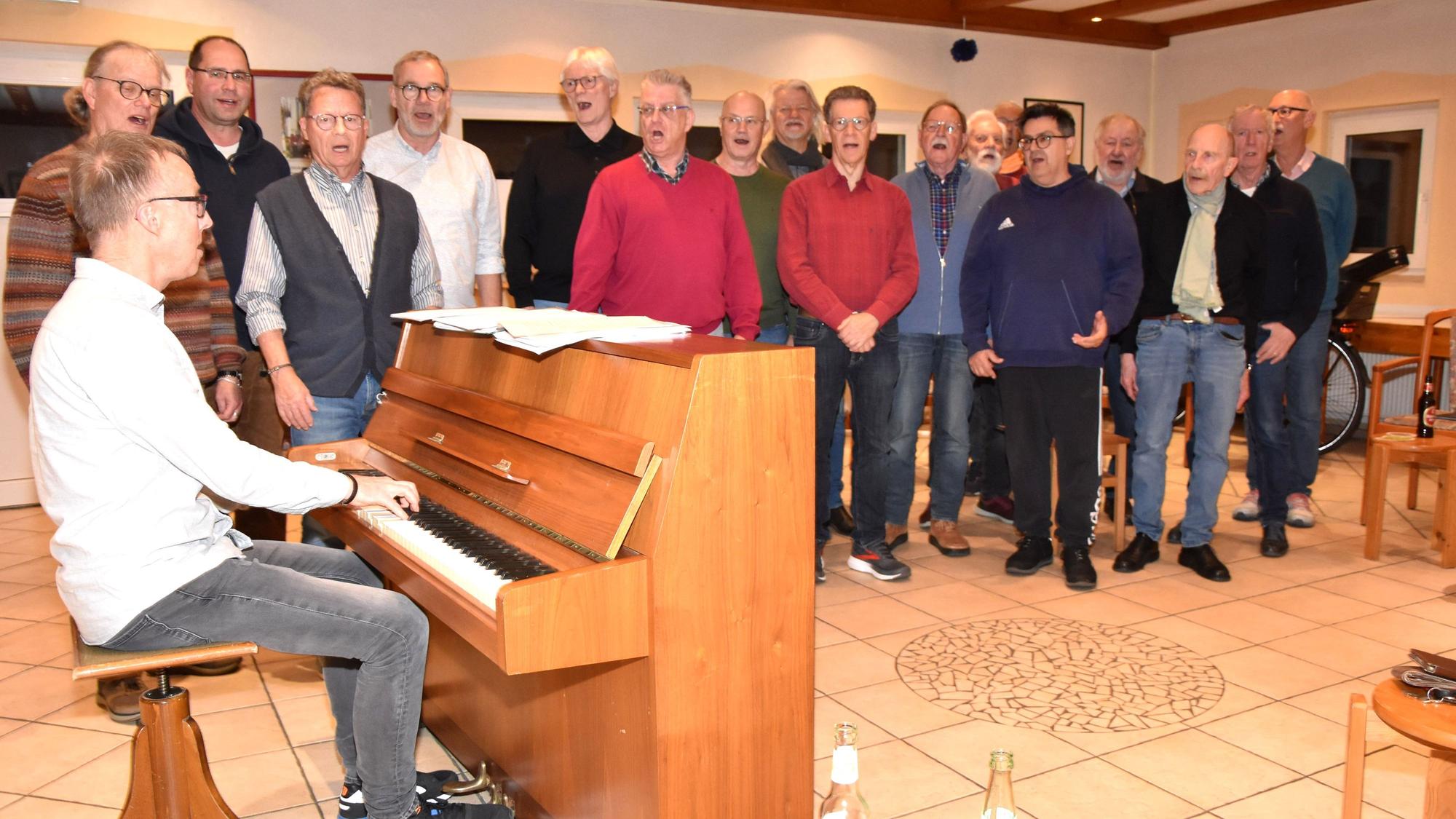 Das Foto zeigt singende Männer und einen Mann am Klavier.