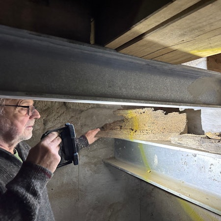 Manfred Bethge im Glockenturm von Sankt Servatius in Siegburg. Er leuchtet von Holzwürmern zerfressene Balkenstücke an, die ausgetauscht wurden. Stahlträger und neue Eichenbalken ersetzen sie jetzt.