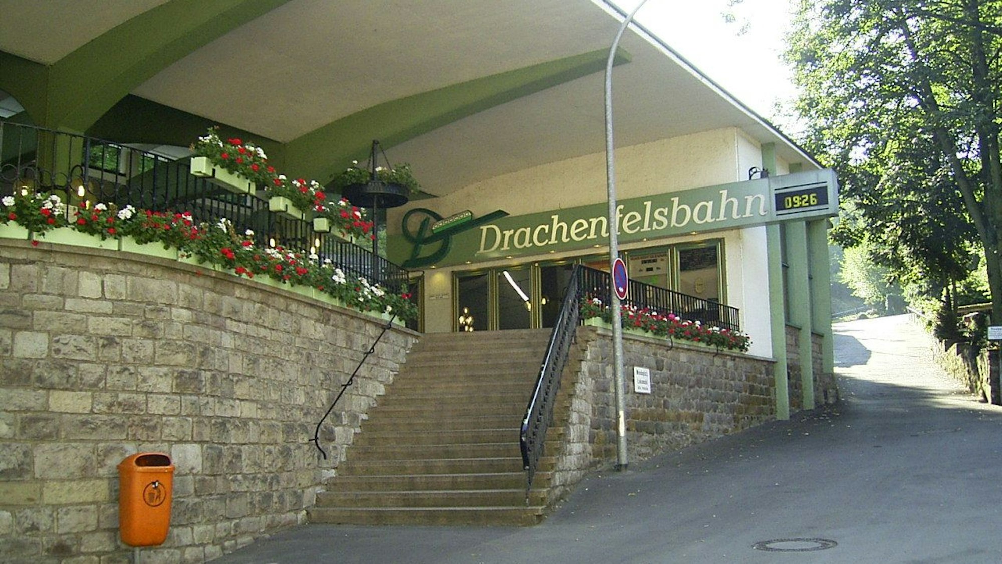 Eine Treppe führt zu Glastüren, darüber der Schriftzug Drachenfelsbahn.