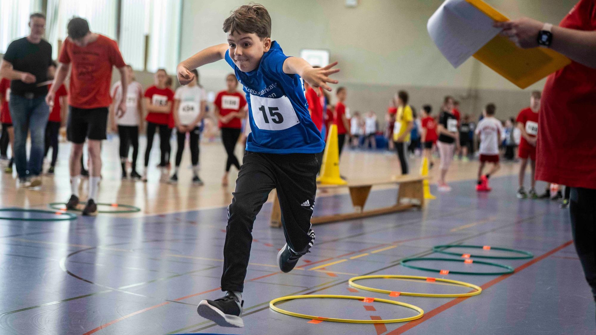 Ein Sportler beim Weitsprung muss zunächst durch bunte Ringe hüpfen.