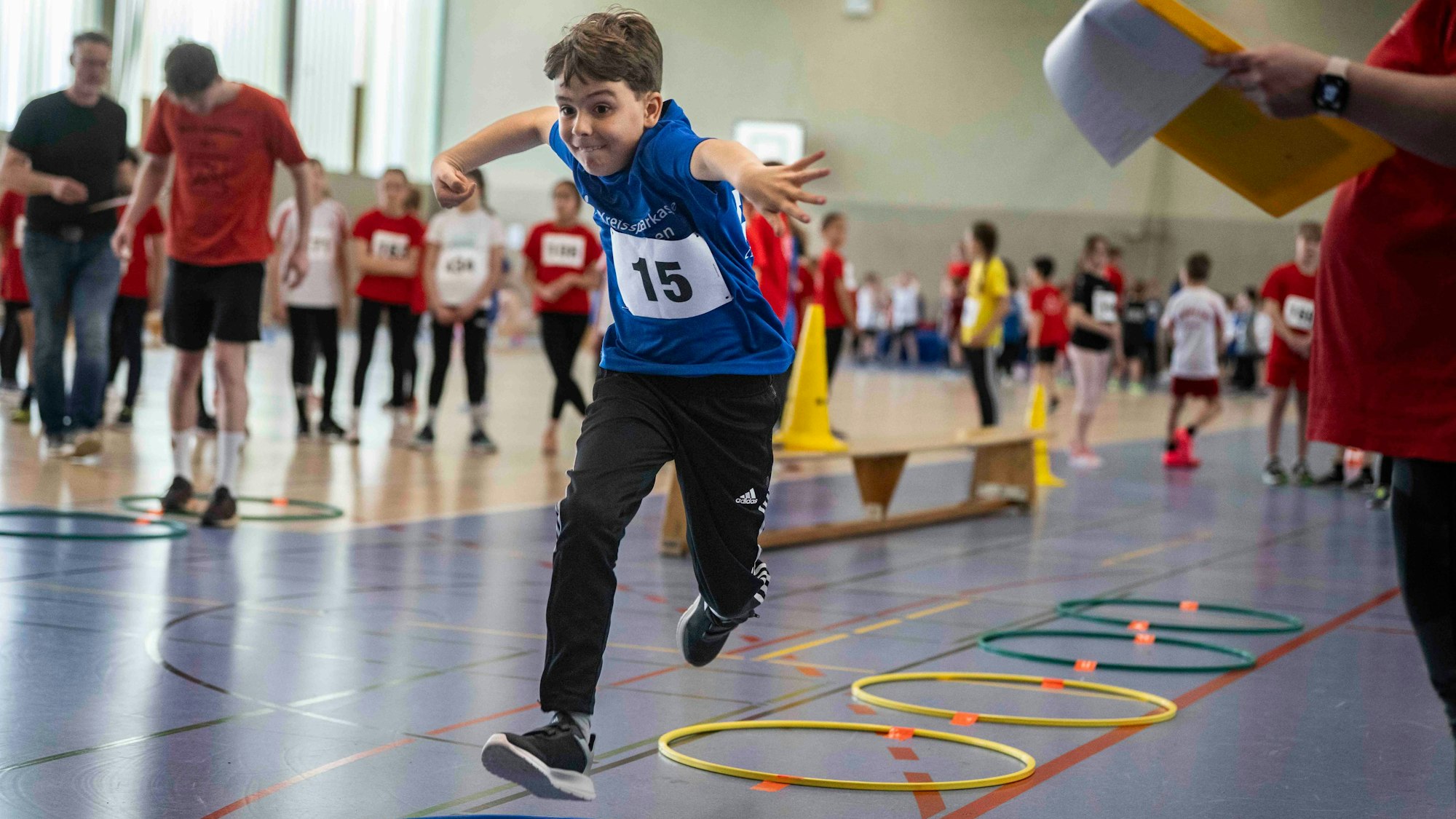 Ein Sportler beim Weitsprung muss zunächst durch bunte Ringe hüpfen.