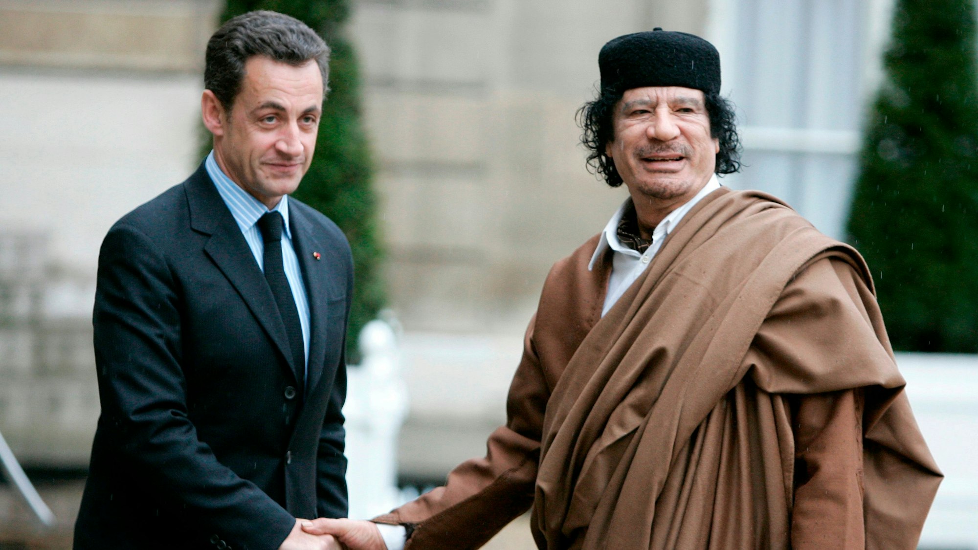ARCHIV - 10.12.2007, Frankreich, Paris: Der damalige französische Präsident Nicolas Sarkozy (l) begrüßt den früheren libyschen Machthaber Muammar al-Gaddafi vor dem Élysée-Palast in Paris. Im Prozess gegen Sarkozy wegen angeblicher Wahlkampfgelder aus Libyen hat die Anklage sieben Jahre Haft gefordert. (zu dpa: «Anklage will sieben Jahre Haft für Sarkozy in Libyen-Affäre») Foto: Francois Mori/AP/dpa +++ dpa-Bildfunk +++