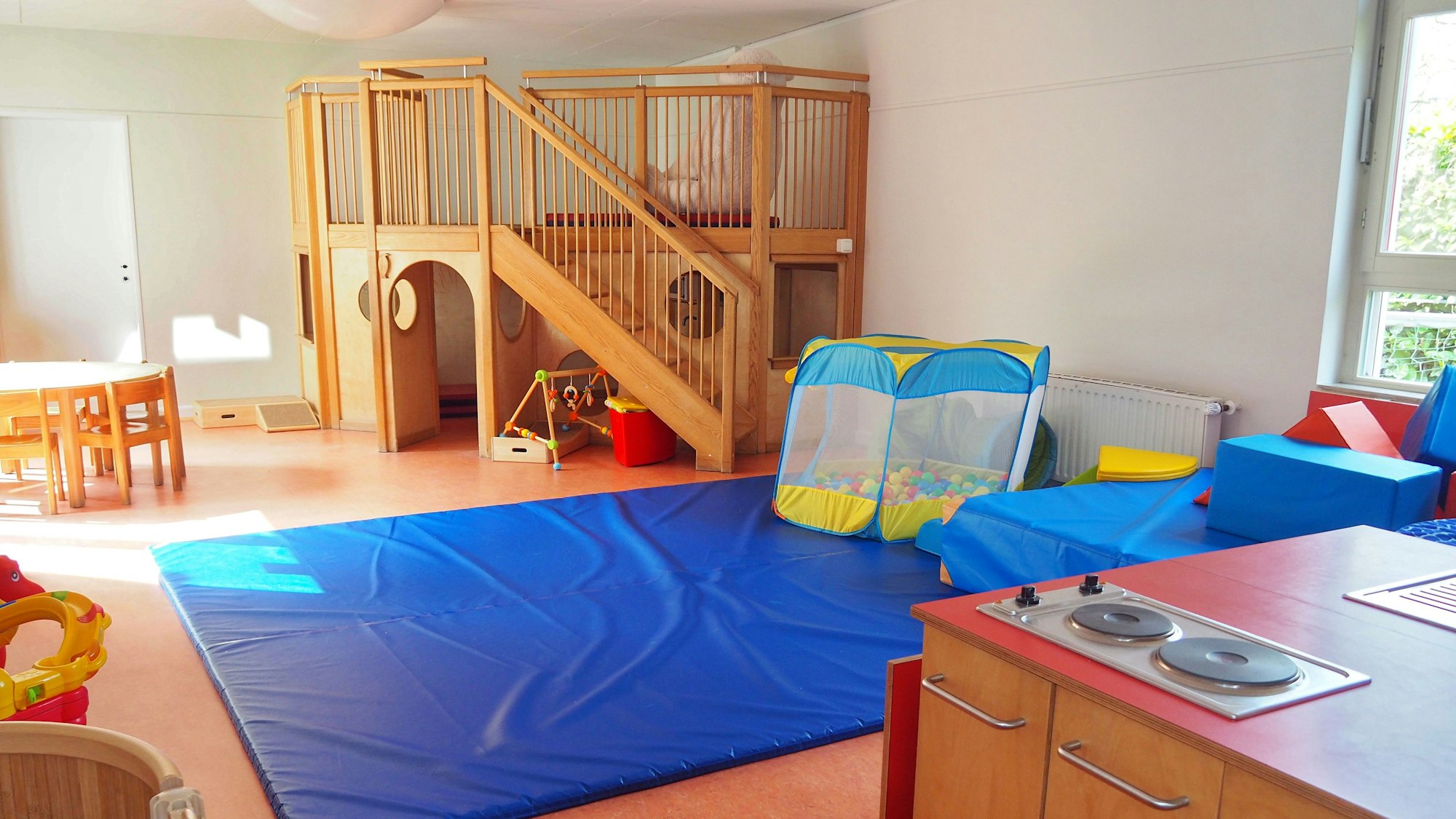 Blick in einen lichtdurchfluteten Raum mit Klettergerüsten und anderen Spielgeräten.