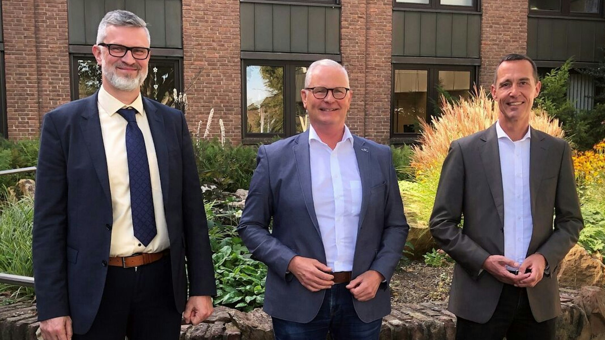 Auf dem Foto sind drei Männer vor dem Kerpener Rathaus zu sehen.