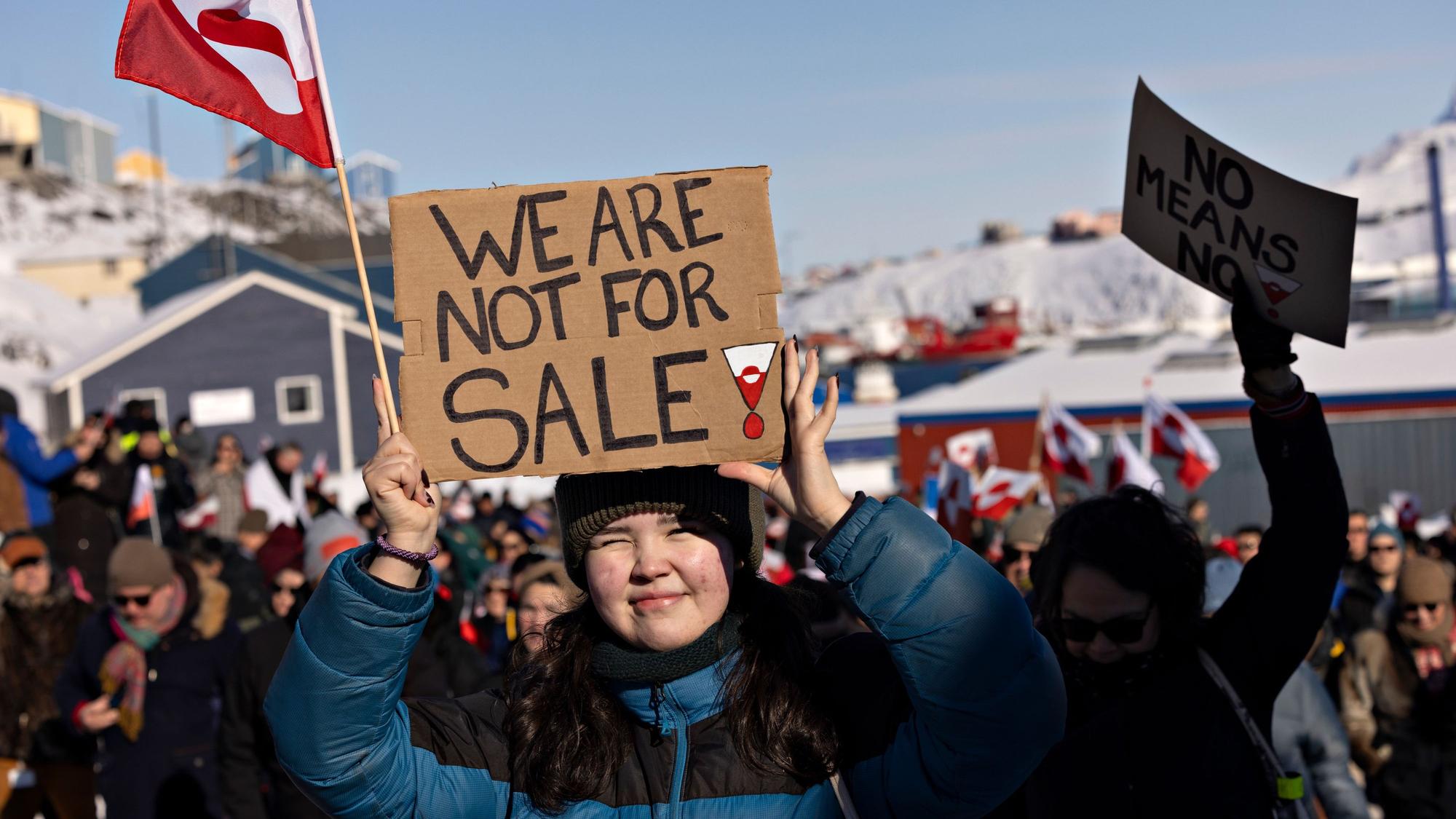 Menschen nehmen an einem Marsch teil, der vor dem US-Konsulat unter dem Motto „Grönland gehört dem grönländischen Volk“ endet. Auf einem Plakat steht geschrieben „We are not for sale!“.