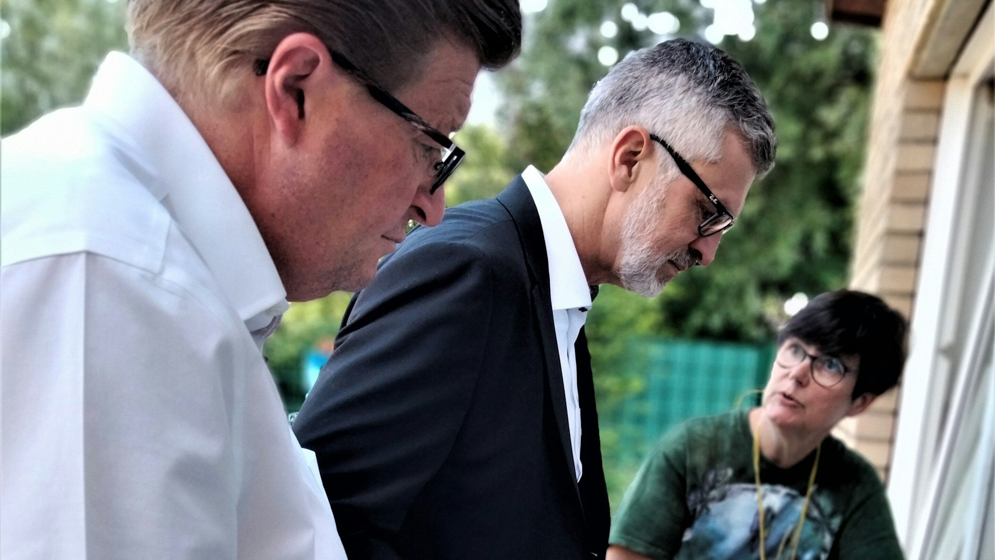 Auf dem Foto sind zwei Männer und eine Frau zu sehen.