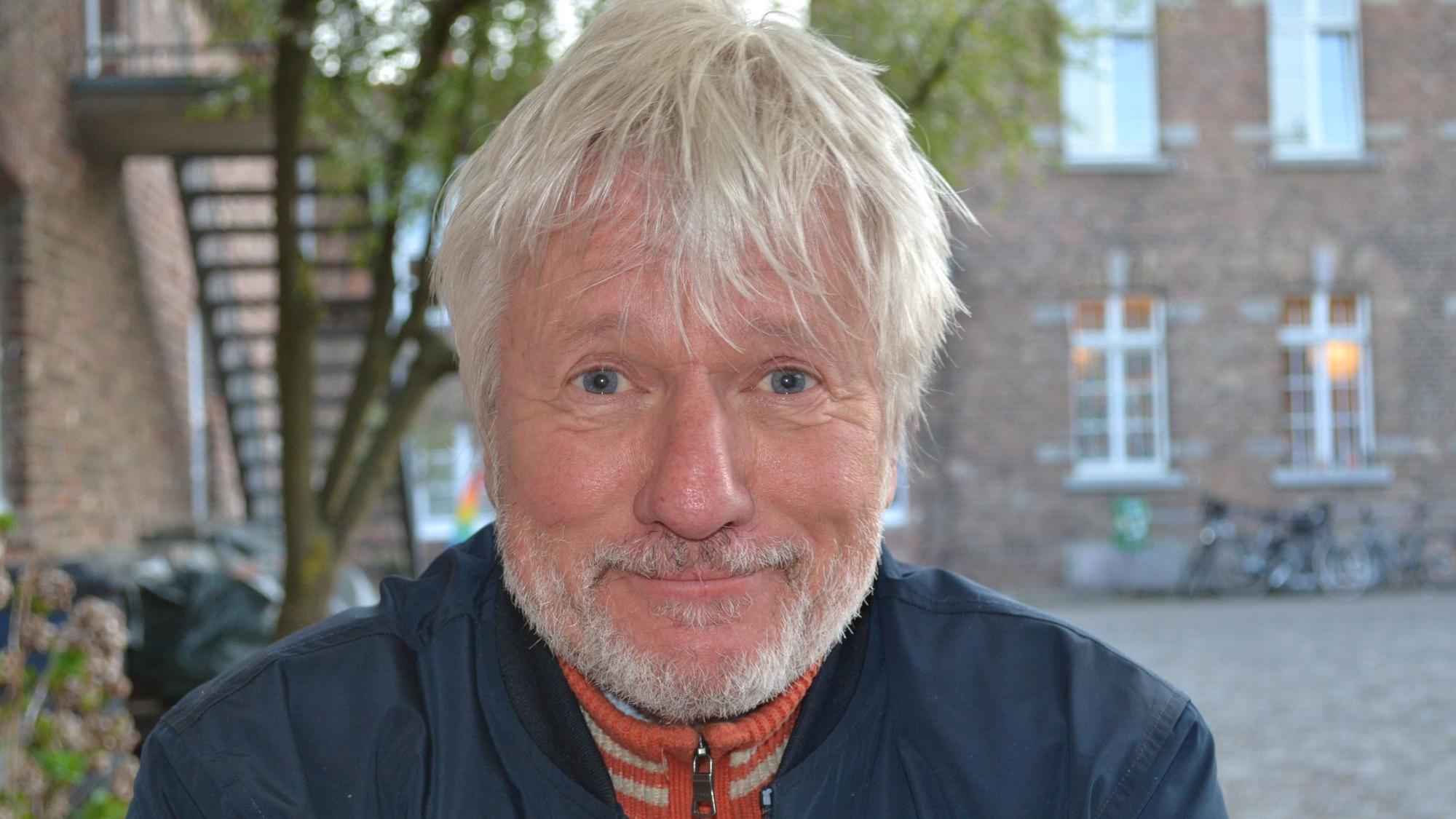 Der Kabarettist Jürgen Becker schmunzelt.