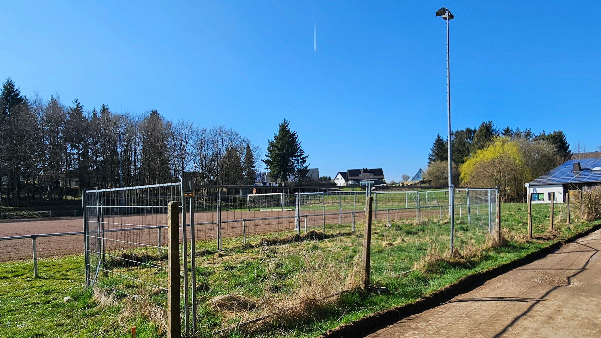 Das Foto zeigt einen mit einem Bauzaun abgesperrten Bereich neben dem Fußballplatz.
