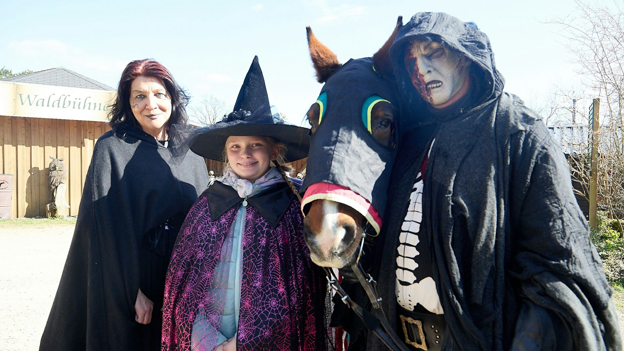 Hermann Klinkhammer steht rechts neben seinem Pferd Linia. Er ist mit einem schwarzen Umhang kostümiert und gruselig als Geisterreiter geschminkt.