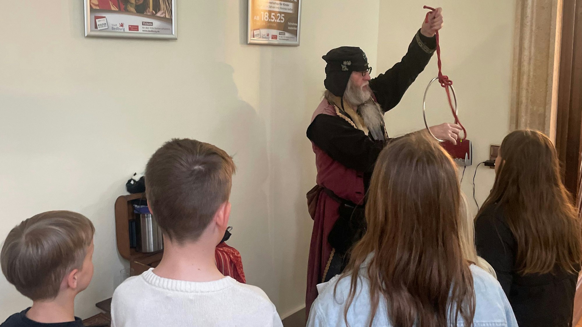 Das Foto zeigt einen Schausteller, der Kinder mit einem Zaubertrick unterhält.