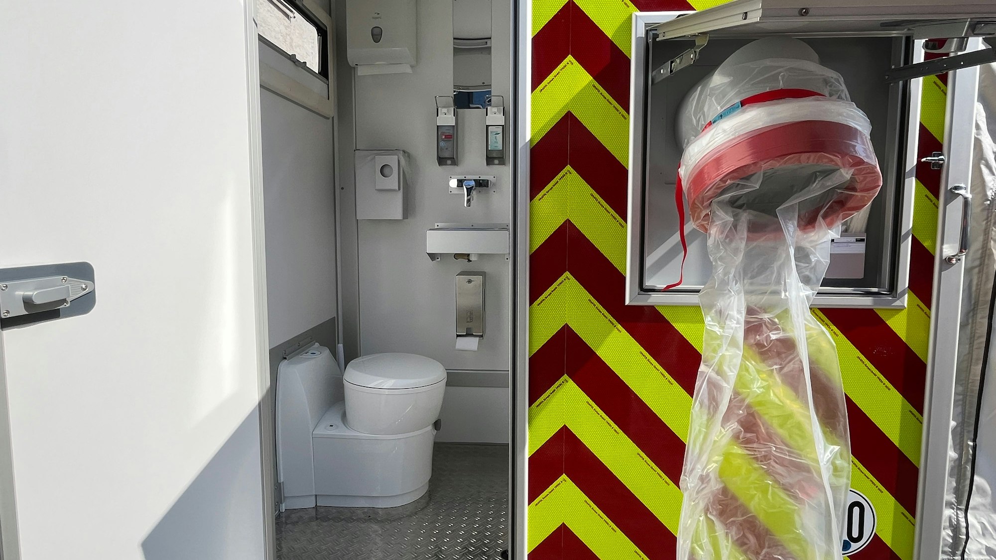 Neben der Durchreiche für verschmutzte Kleidung gibt es eine chemische Toilette.