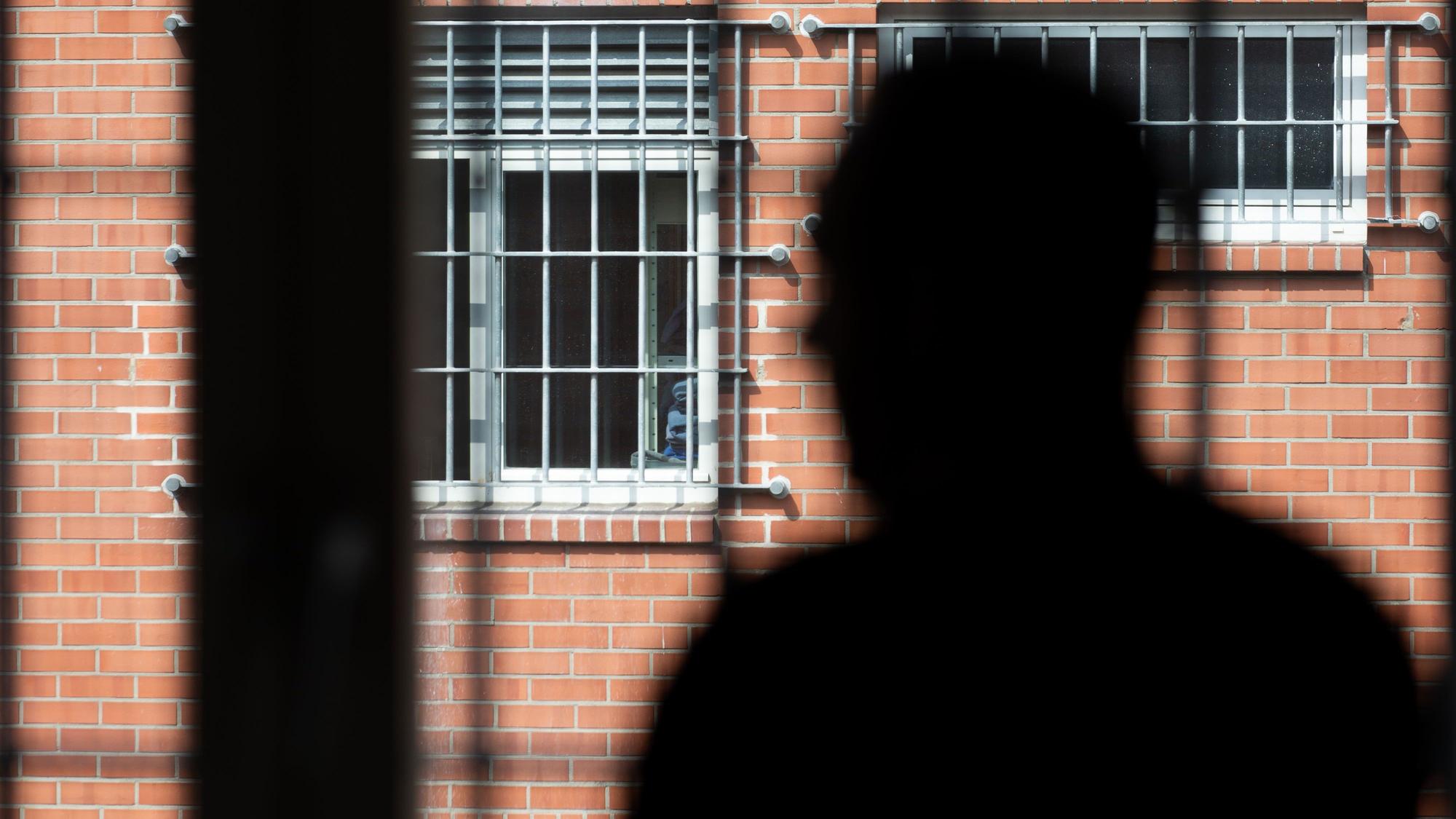 Ein Insasse steht vor einem vergitterten Fenster in der Unterbringungseinrichtung für Ausreisepflichtige (UfA) in Büren.