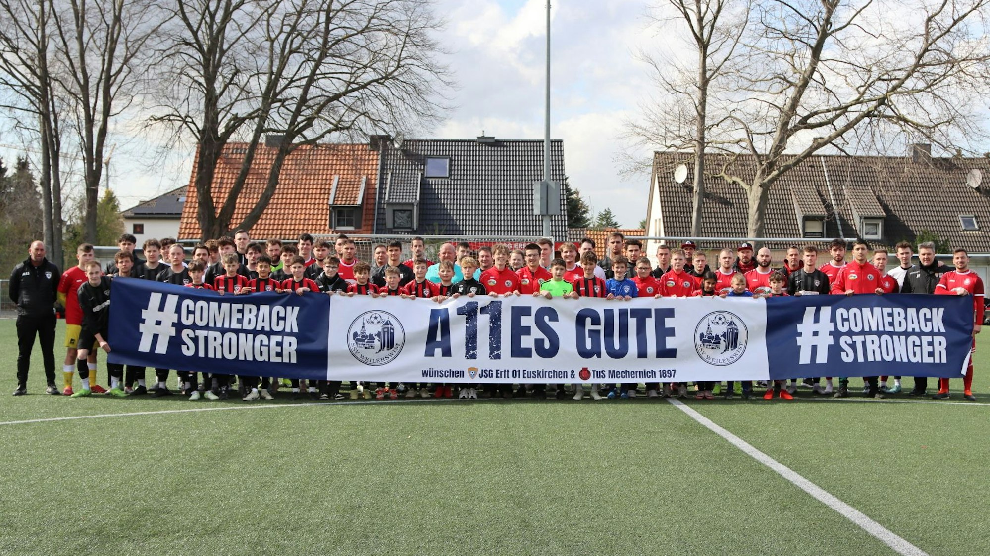Die Mannschaften der JSG Erft und der TuS Mechernich halten ein Plakat hoch, auf dem "A11es Gute, #ComebackStronger" steht.